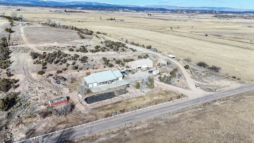 Aerial overview of property's location with rural landscape and a mountainous background