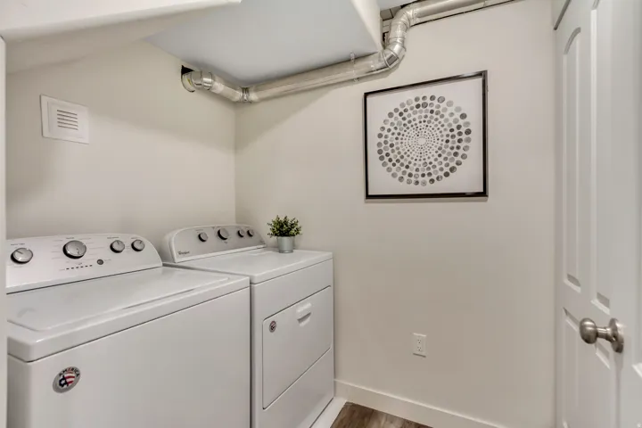 Washroom featuring wood finished floors and washing machine and clothes dryer
