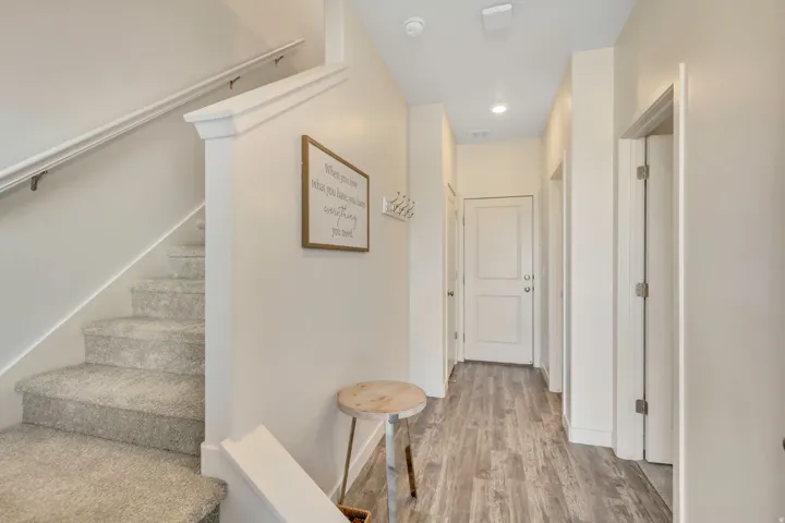 Corridor with stairs, light wood finished floors, and recessed lighting