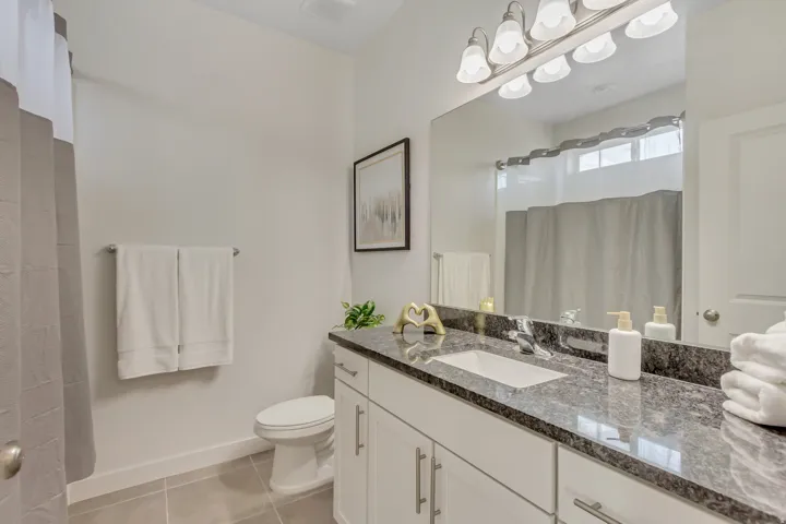 Bathroom featuring a shower with shower curtain, vanity, and light tile patterned flooring