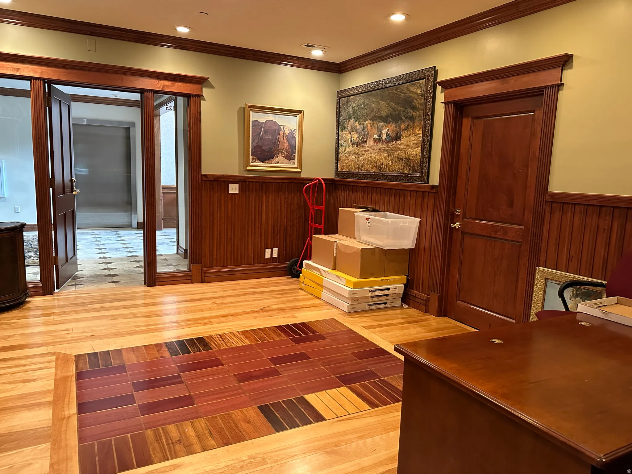 Unfurnished office with a wainscoted wall, light wood-type flooring, ornamental molding, and recessed lighting