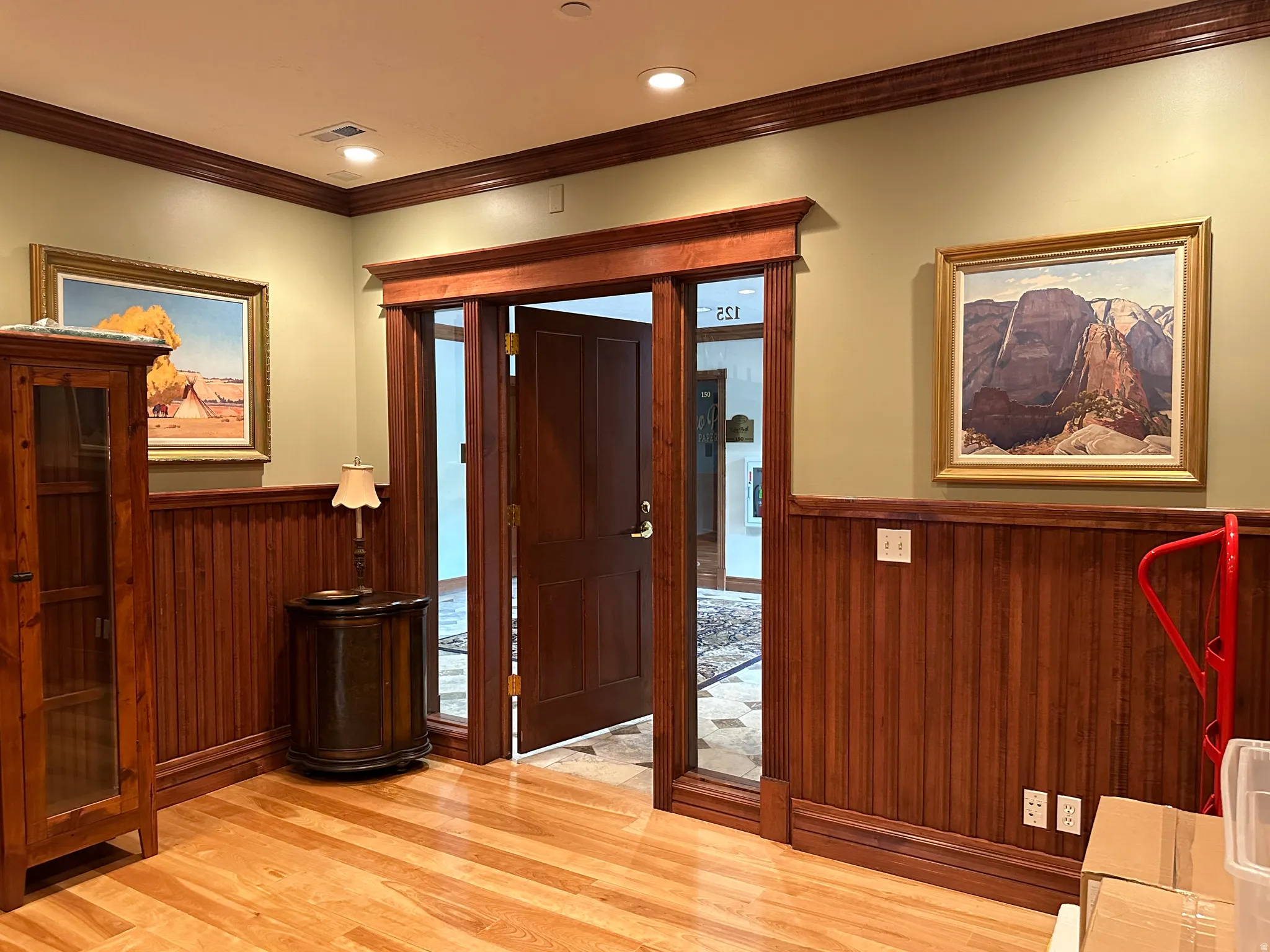 Hall with wainscoting, light wood-style floors, wood walls, recessed lighting, and ornamental molding