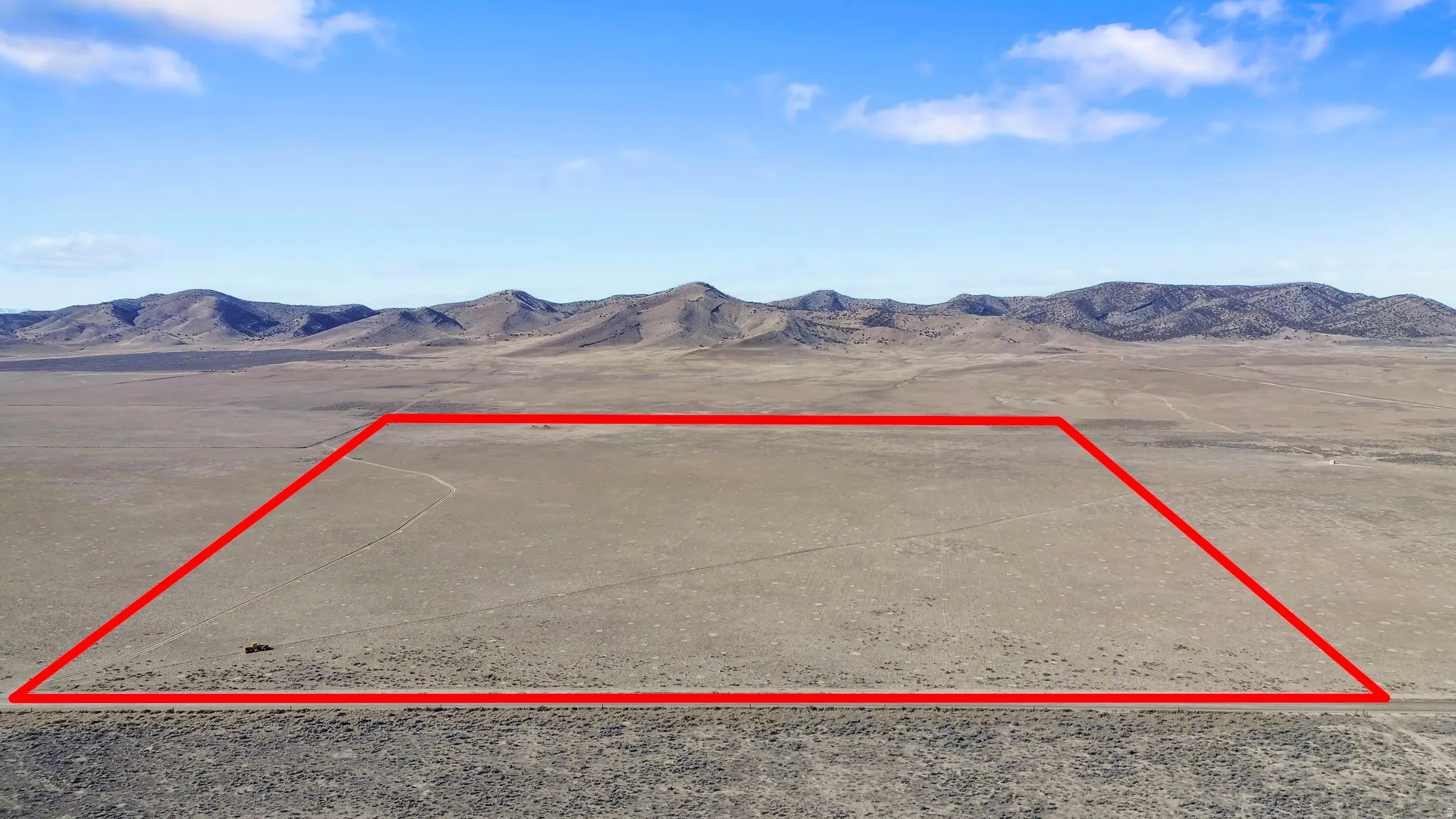 Aerial view of property and surrounding area featuring mountains and property boundaries highlighted