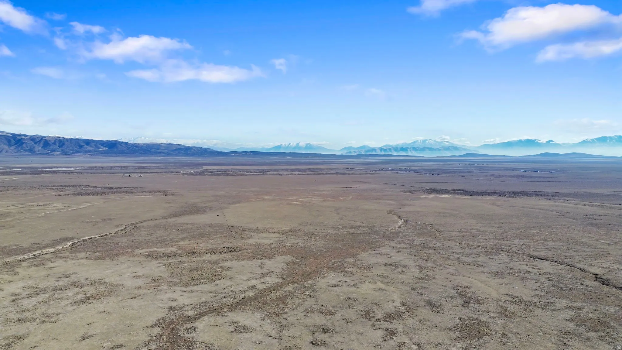 Aerial view of sparsely populated area featuring a mountainous background and a desert landscape
