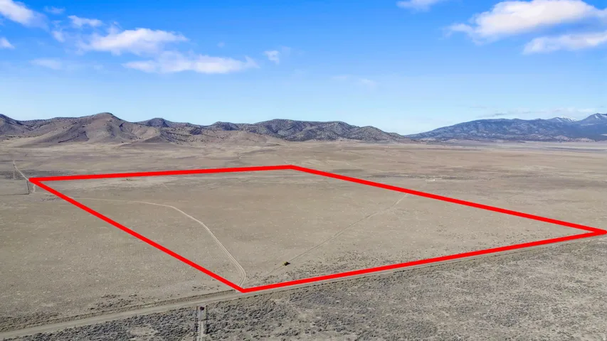Aerial overview of property's location featuring a mountain backdrop and property parcel outlined