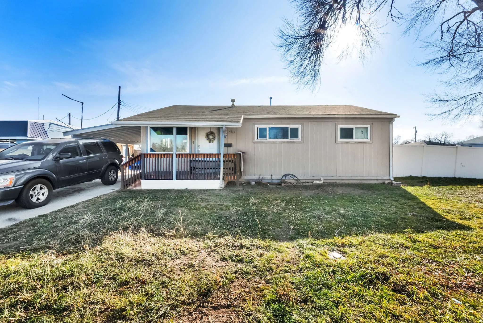 View of front of property with an attached carport, a porch, and concrete driveway