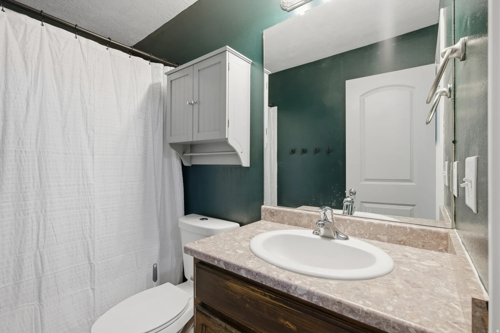 Full bath featuring vanity and curtained shower