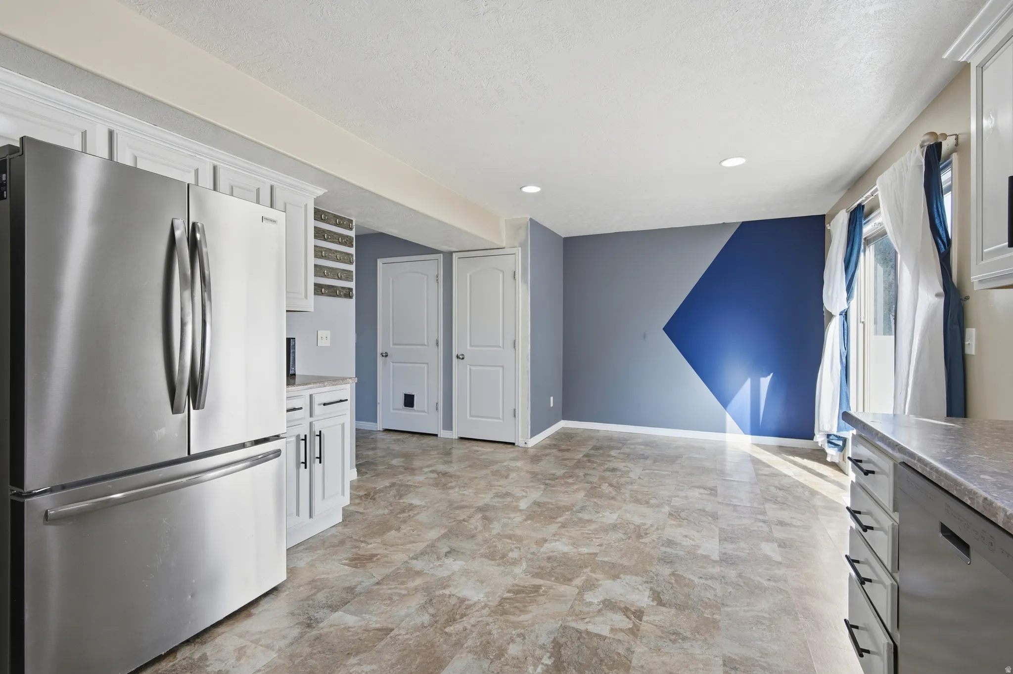 Kitchen with stainless steel appliances, white cabinetry, and recessed lighting