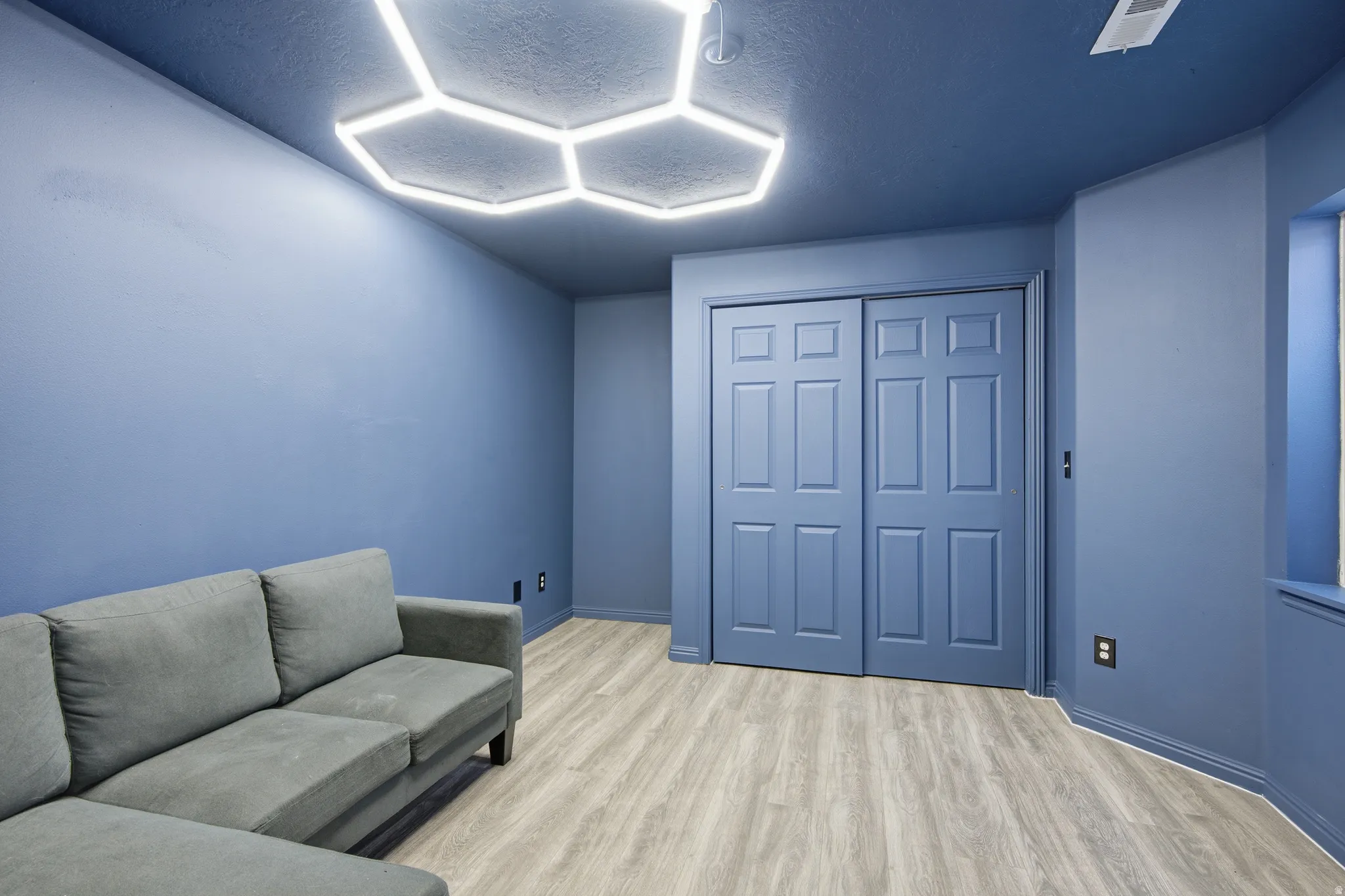 Bedroom with vinyl wood look floors and a textured ceiling