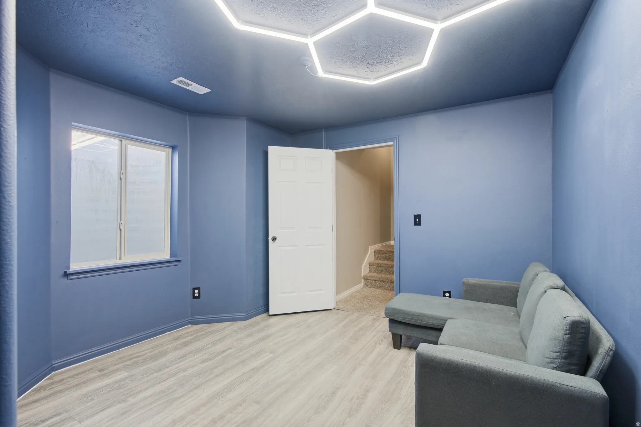 Bedroom with vinyl wood look floors and a textured ceiling