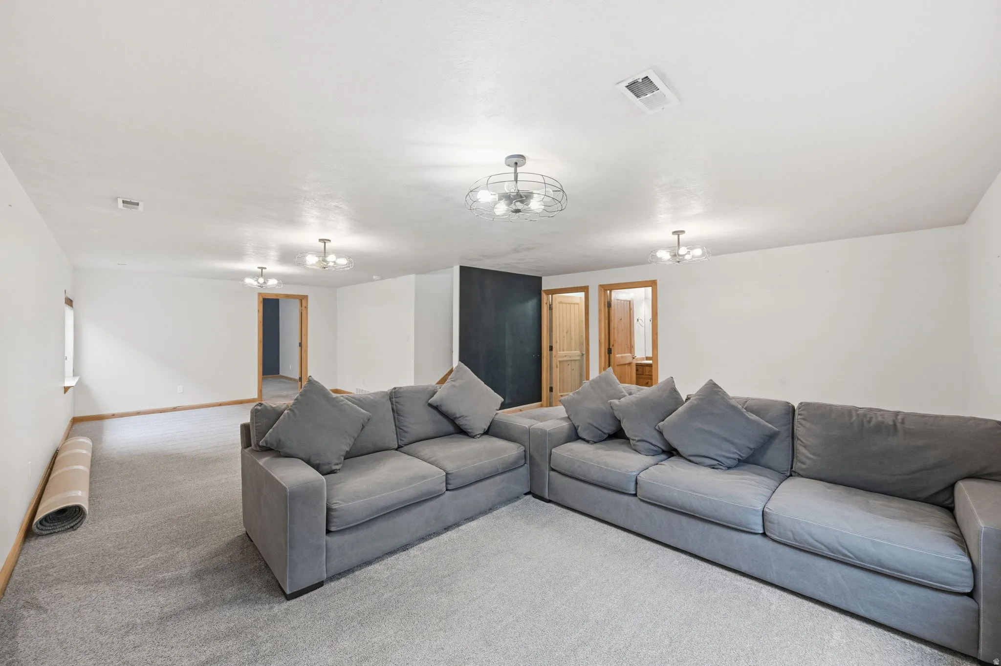 Carpeted living area with baseboards and a chandelier