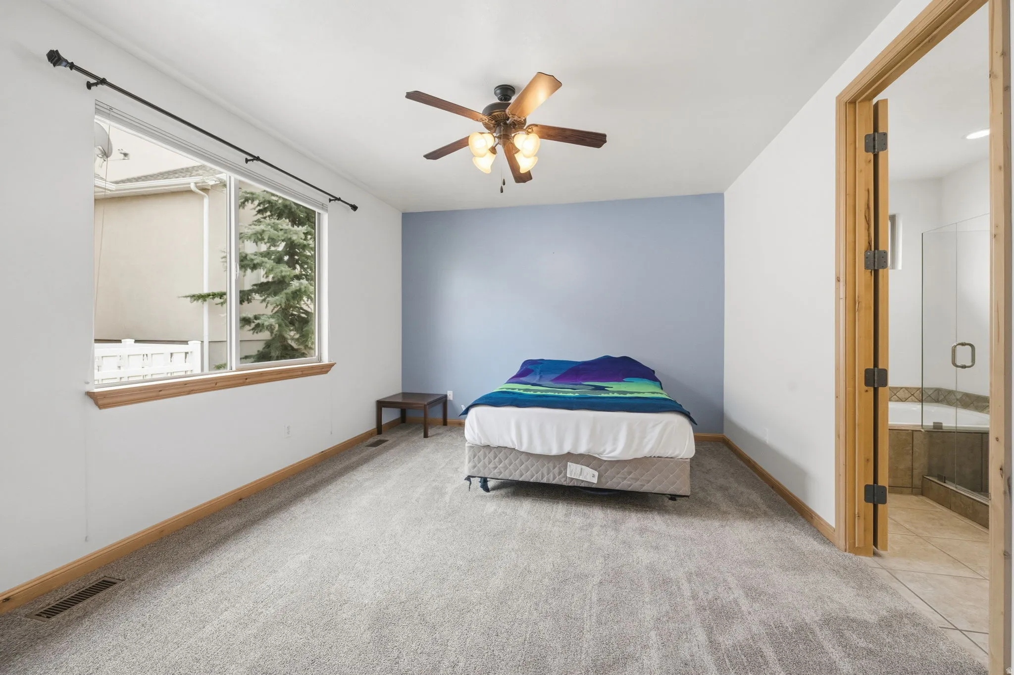 Bedroom with light colored carpet and a ceiling fan