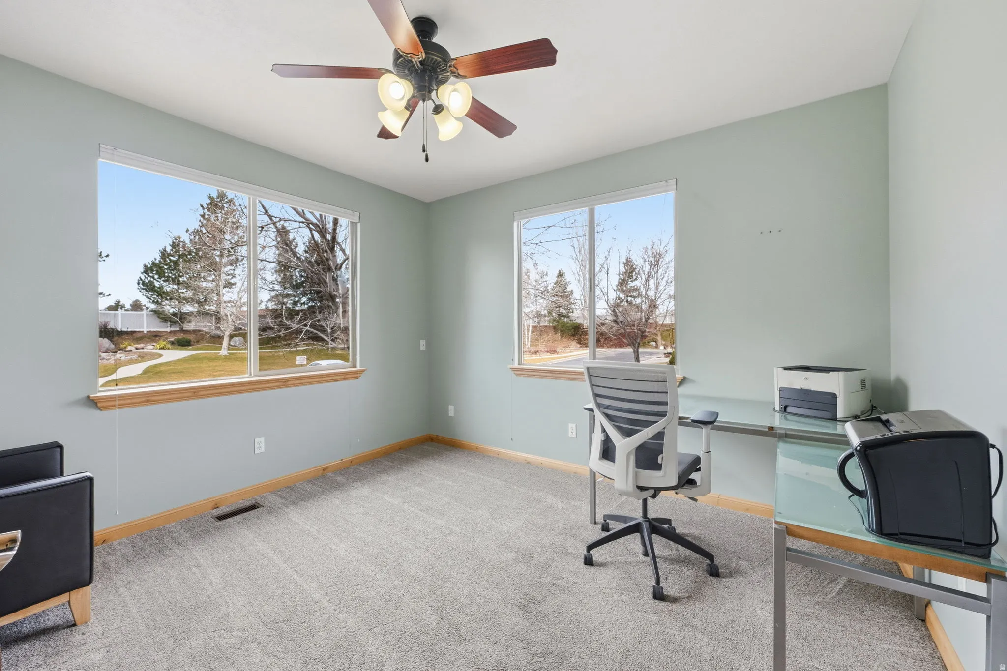 Office area featuring light carpet and ceiling fan