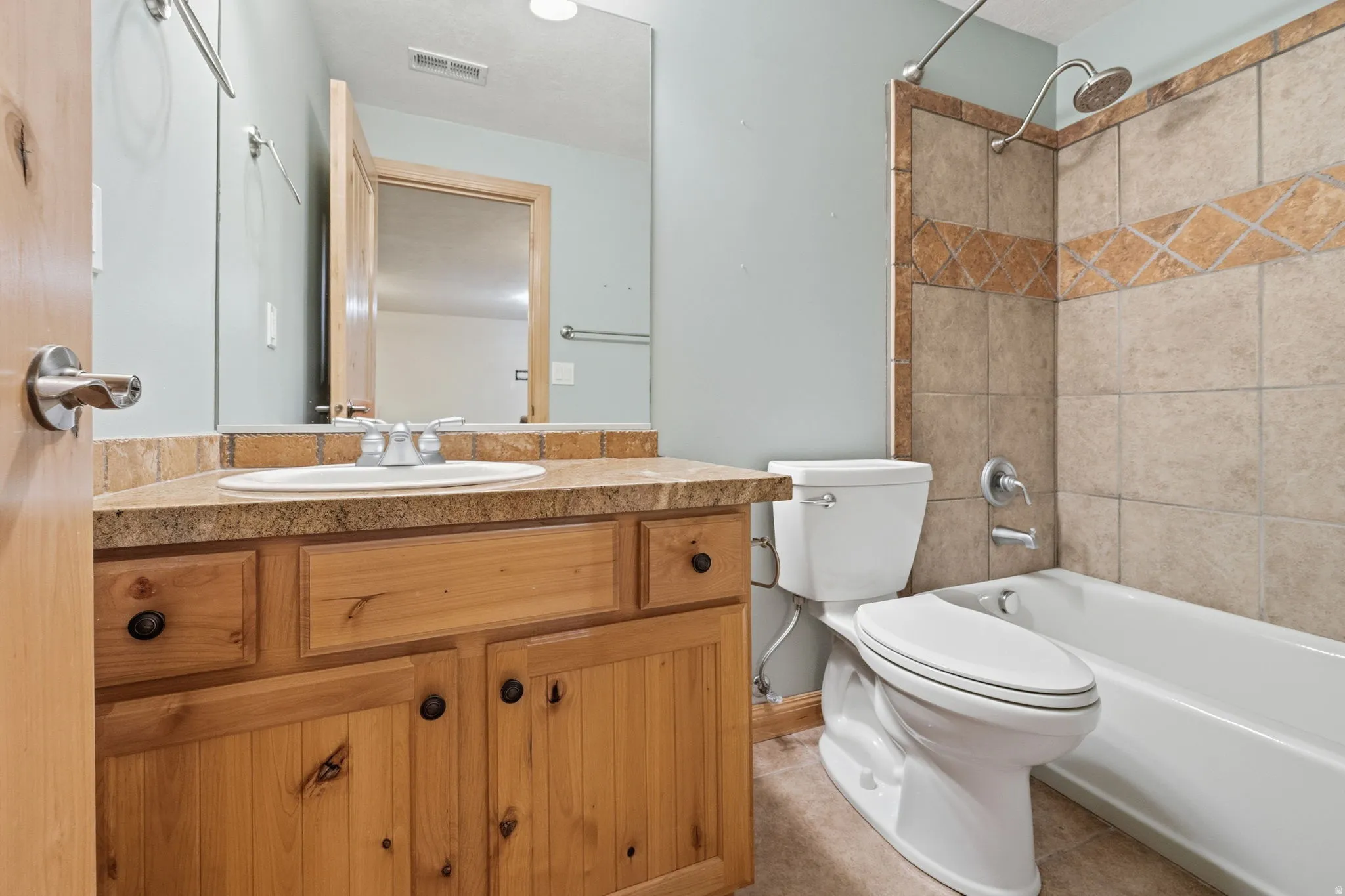 Full bathroom featuring bathing tub / shower combination, vanity, and light tile patterned floors