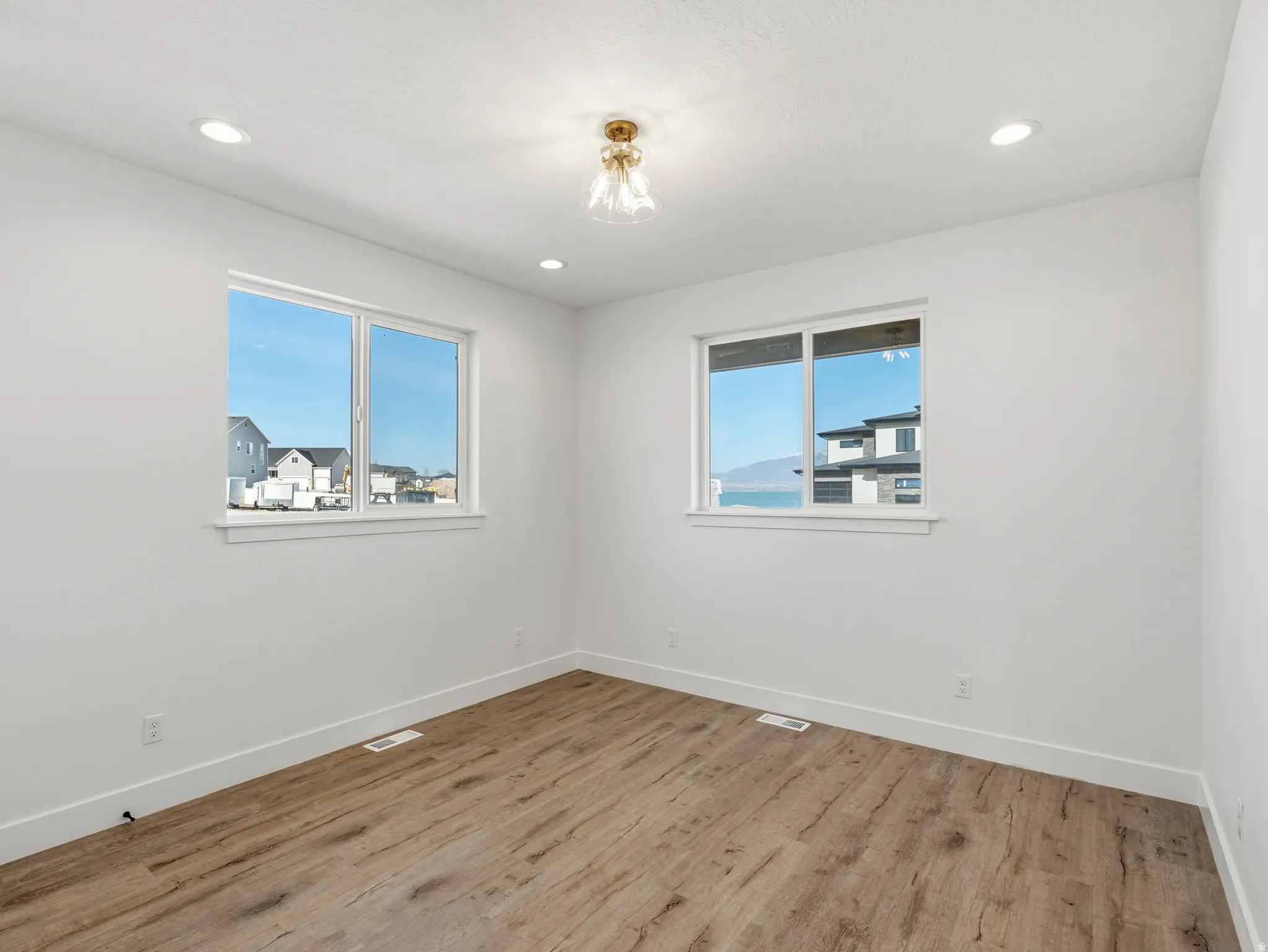 Unfurnished room with light wood-style floors, healthy amount of natural light, and recessed lighting