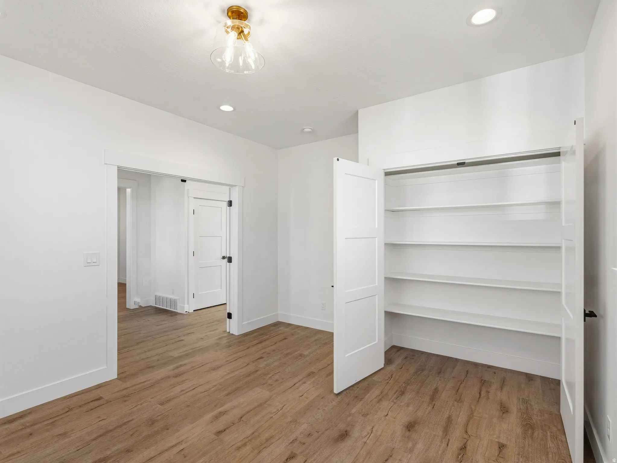 Unfurnished bedroom featuring recessed lighting, light wood-style flooring, and a closet
