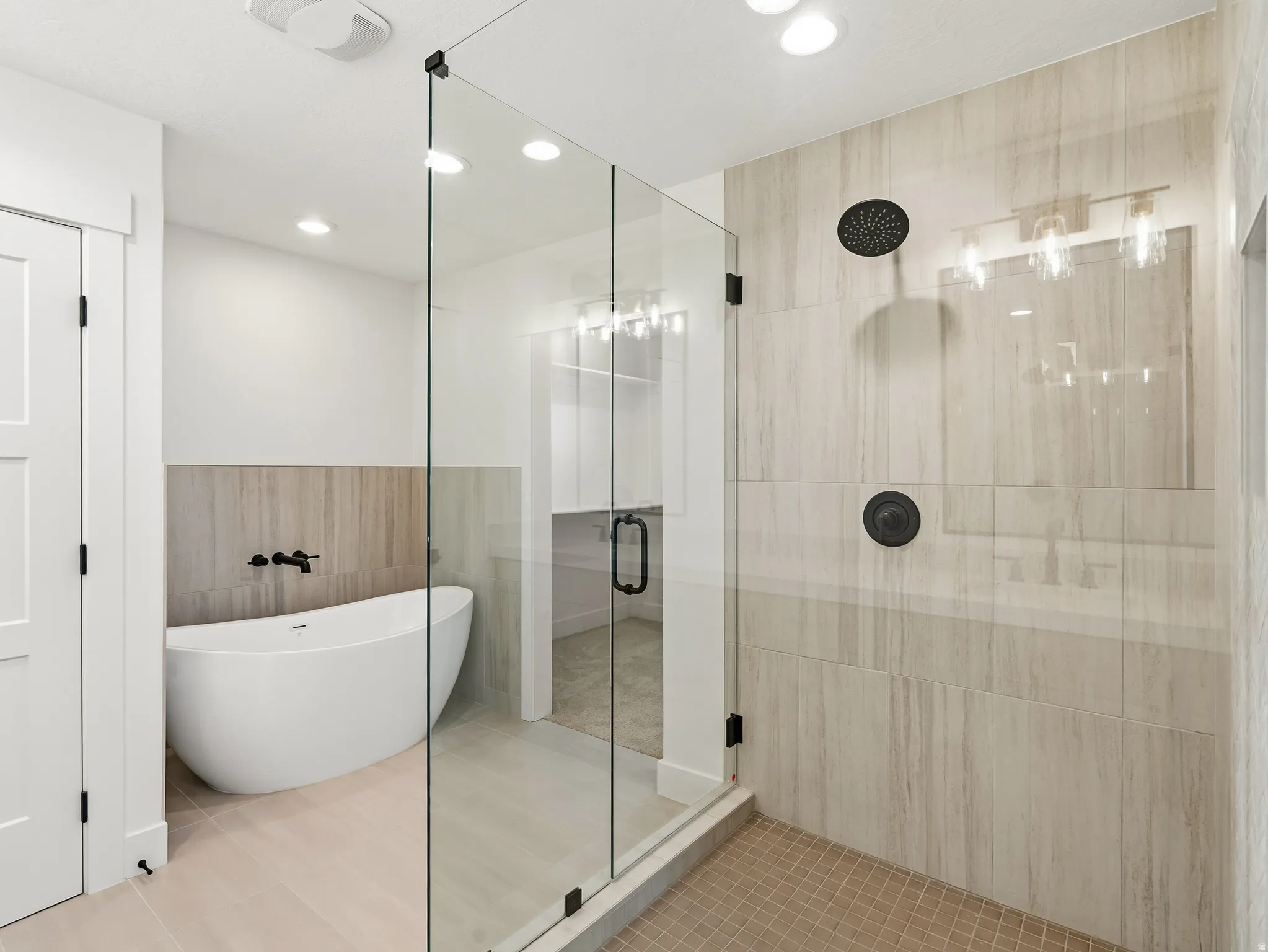 Bathroom featuring a stall shower, tile walls, a soaking tub, wainscoting, and recessed lighting