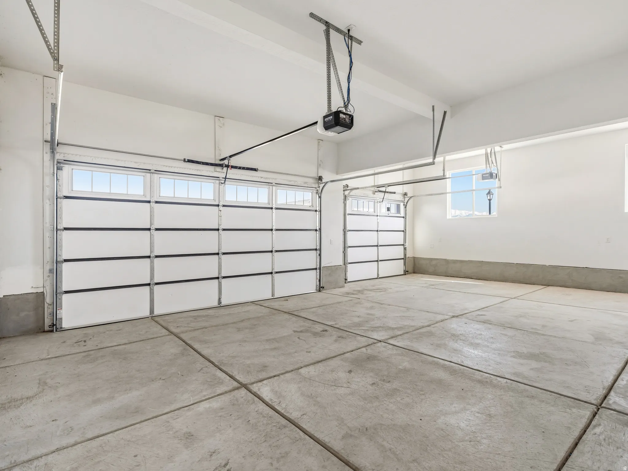Three car garage featuring a garage door opener