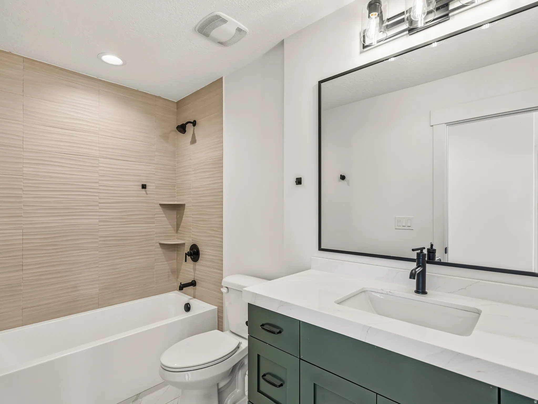 Bathroom featuring shower / bathtub combination, vanity, and recessed lighting
