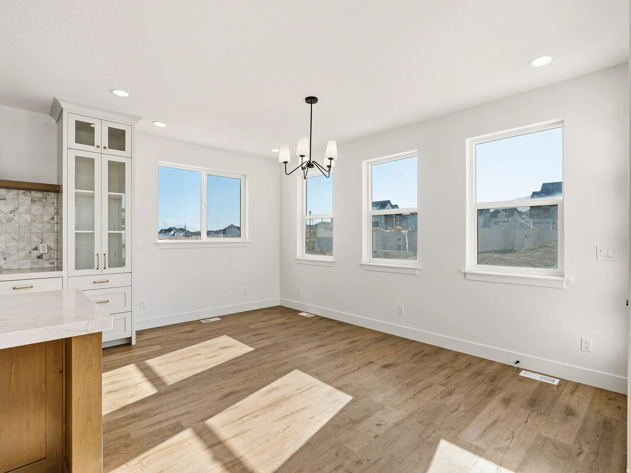 Unfurnished dining area featuring light wood-style flooring and hanging lights