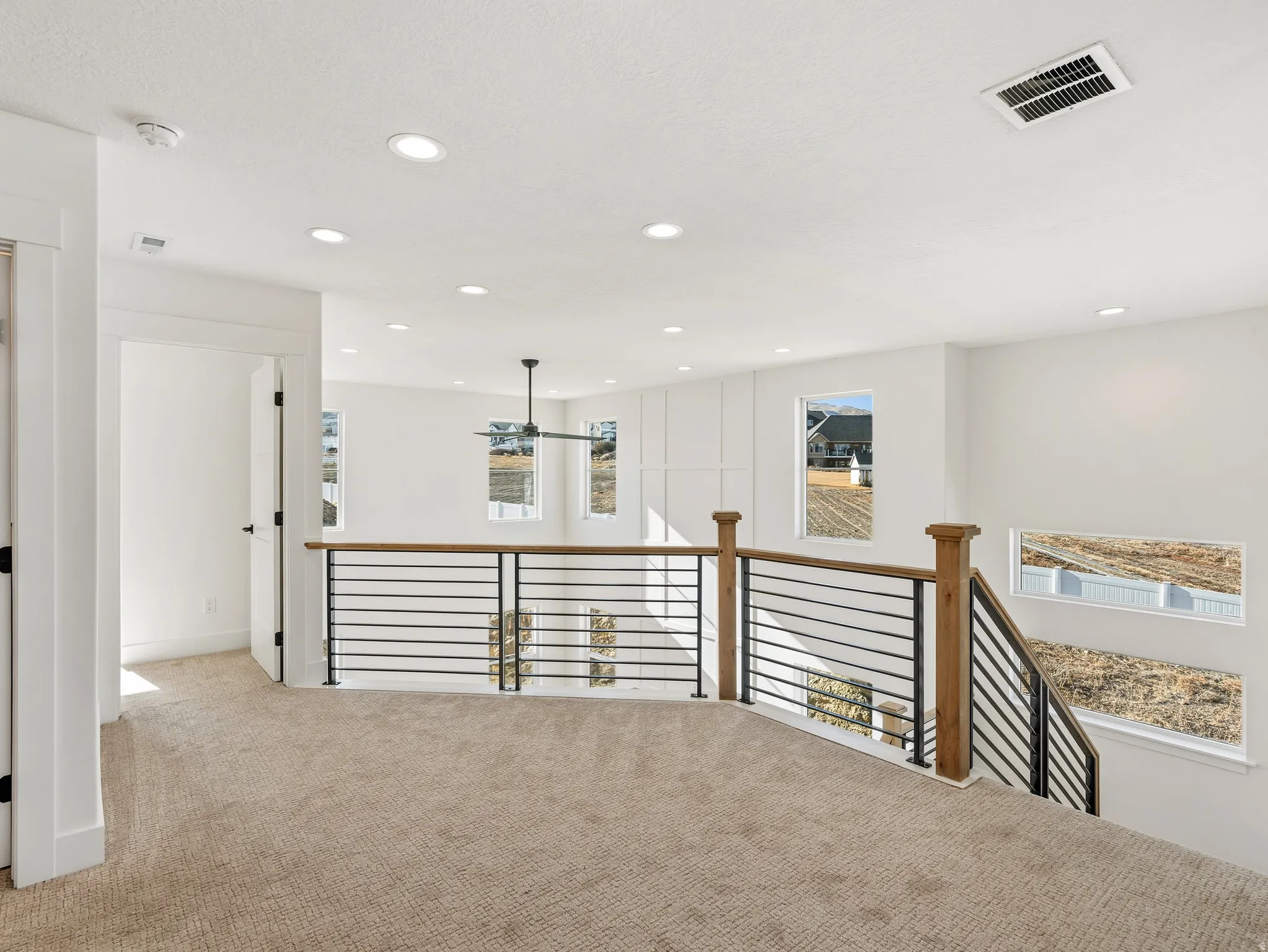 Hallway featuring carpet floors, an upstairs landing, and recessed lighting