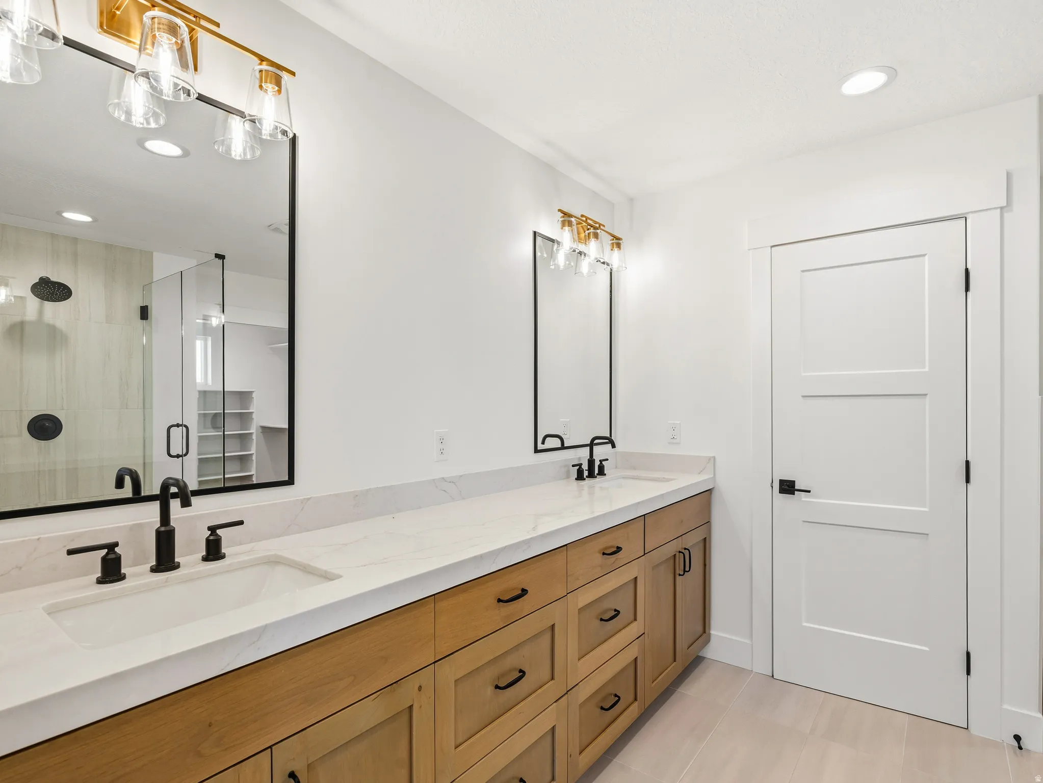 Primary bathroom featuring recessed lighting, double vanity, a shower stall, and light tile patterned floors
