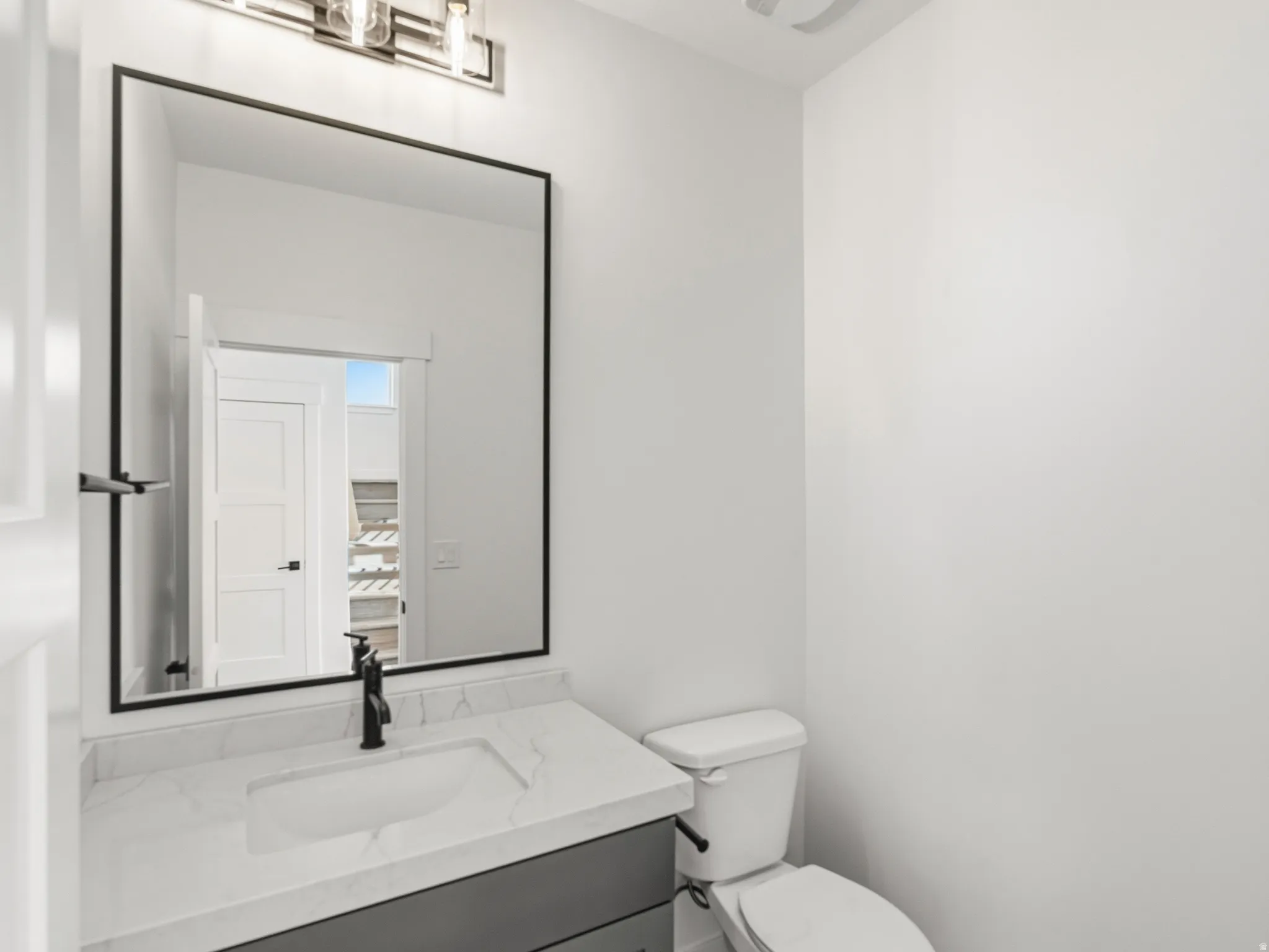 Half bathroom featuring vanity and toilet