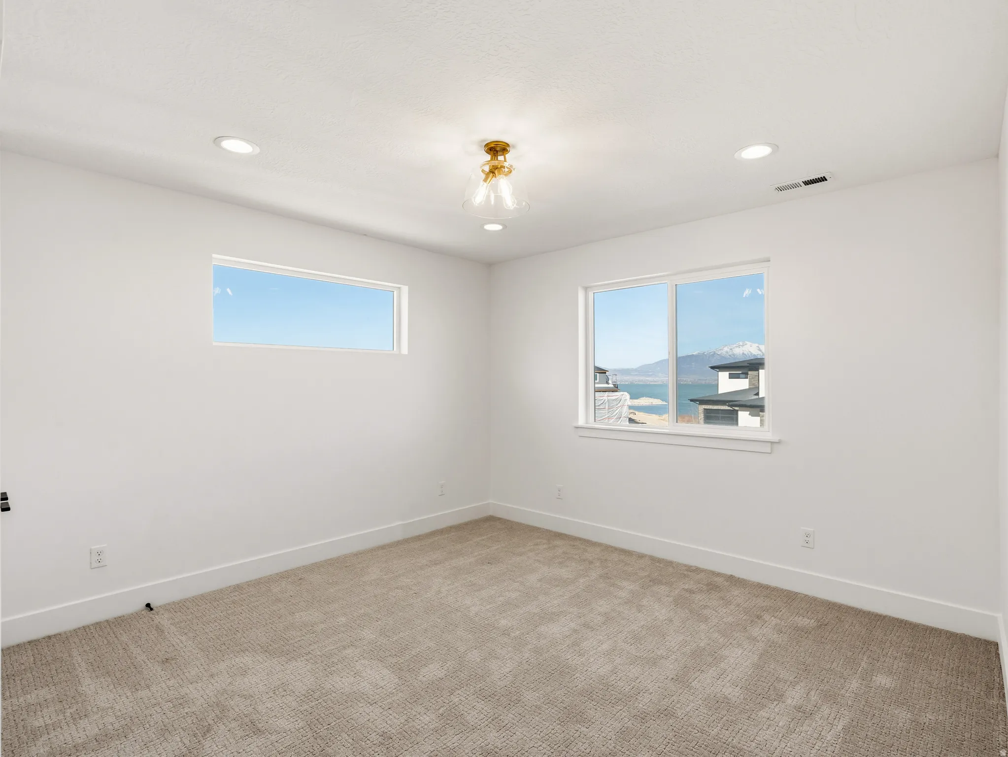 Upstairs bedroom with light carpet and recessed lighting