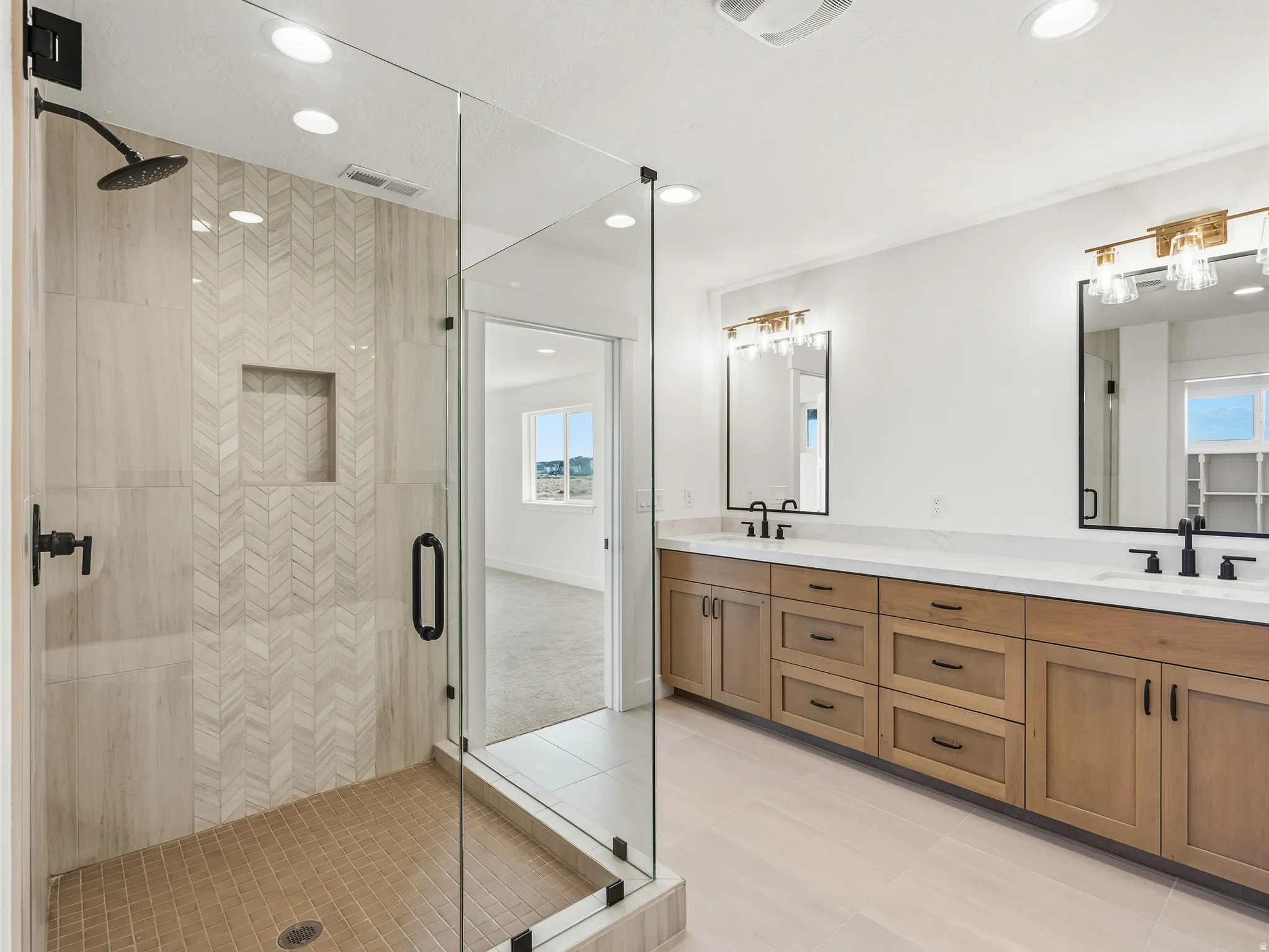 Primary bathroom featuring a shower stall, double vanity, light tile patterned floors, and recessed lighting