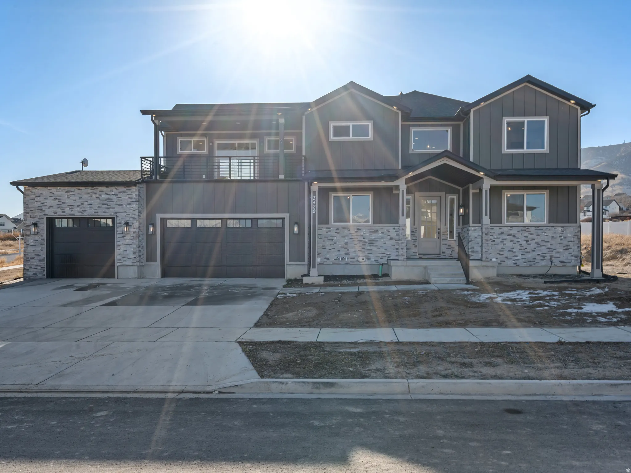 View of front of house with stone siding, concrete driveway, a porch, board and batten siding, and an attached garage