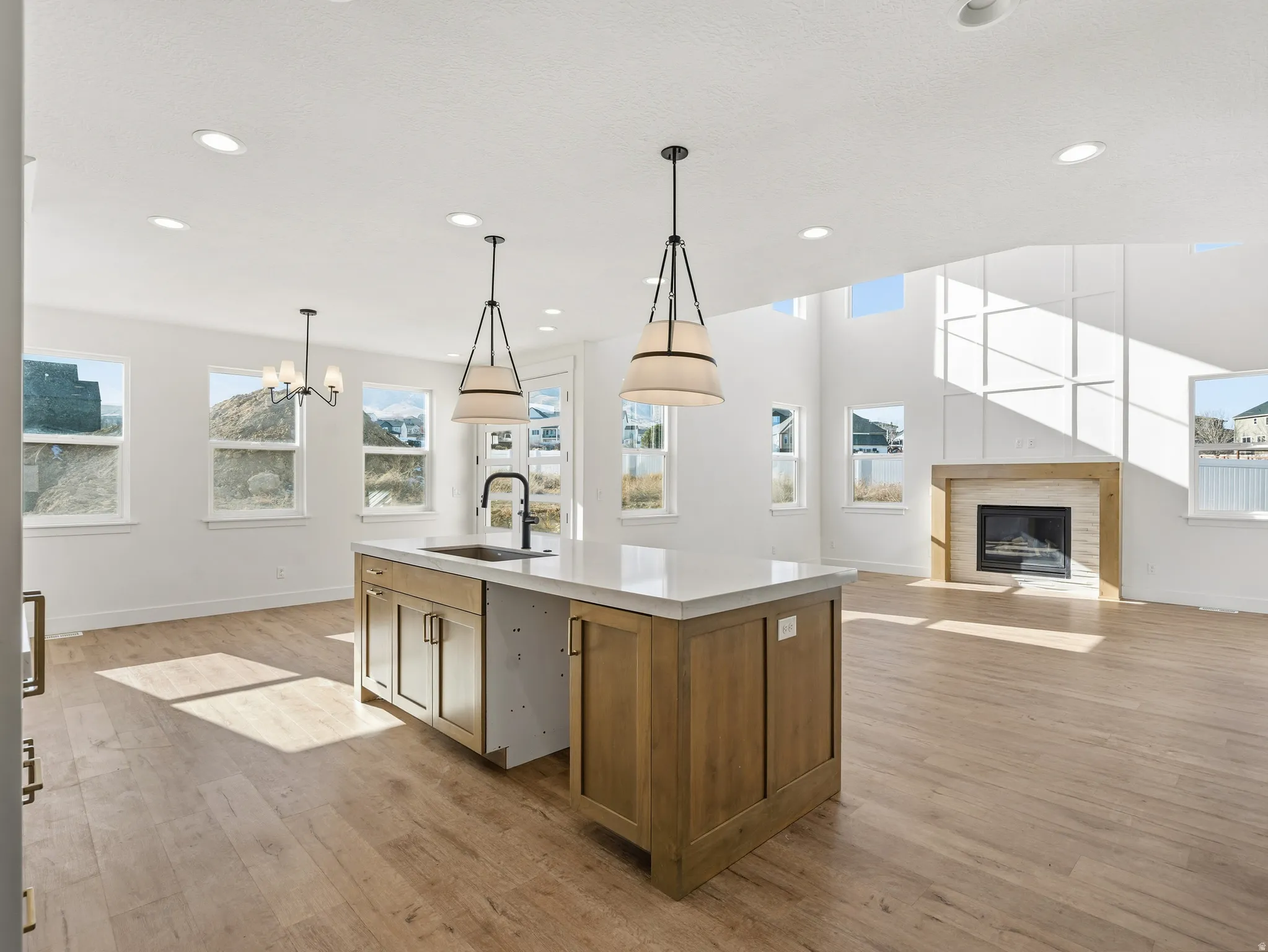 Kitchen featuring open floor plan, wood finish cabinets, light wood-style flooring, and an island with sink