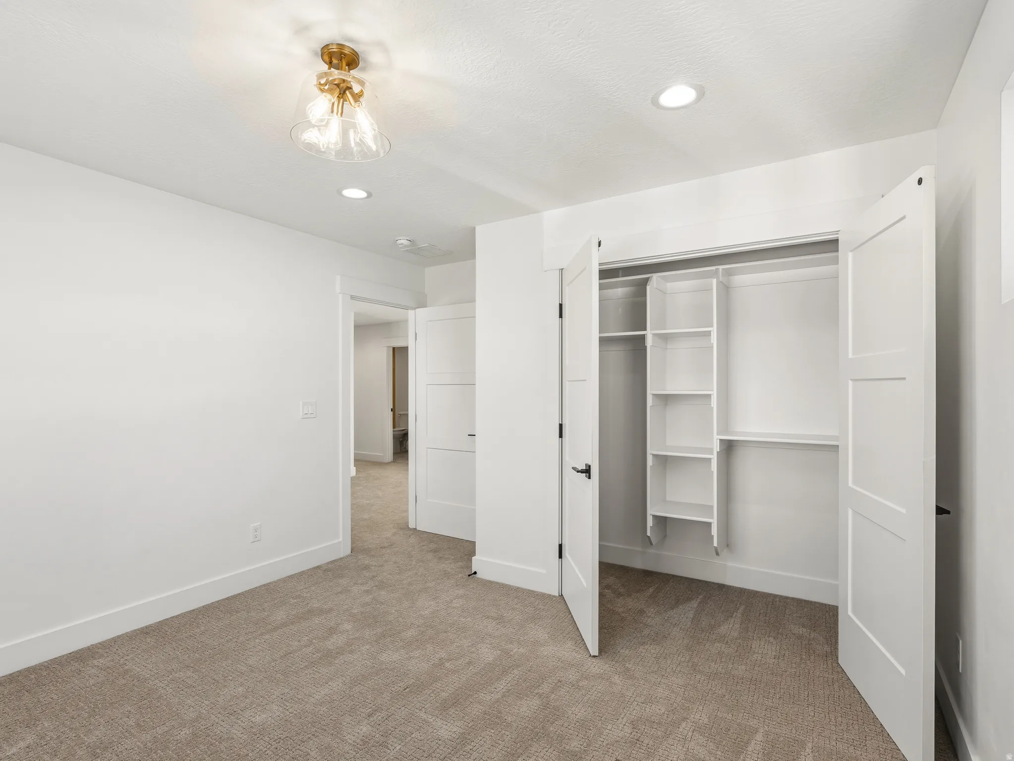 bedroom with recessed lighting, light colored carpet, and a closet
