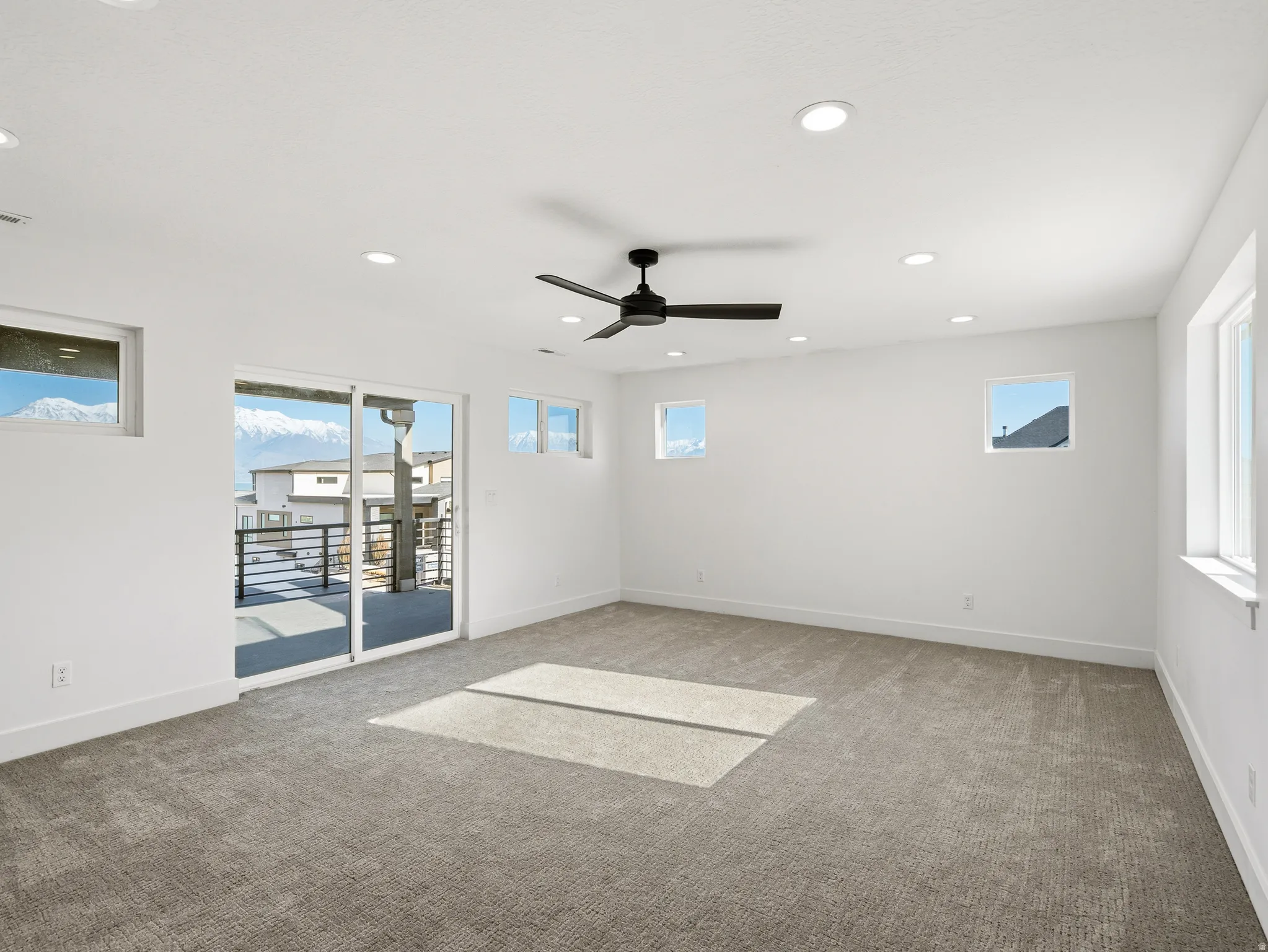 Primary bedroom featuring light colored carpet, recessed lighting, and ceiling fan