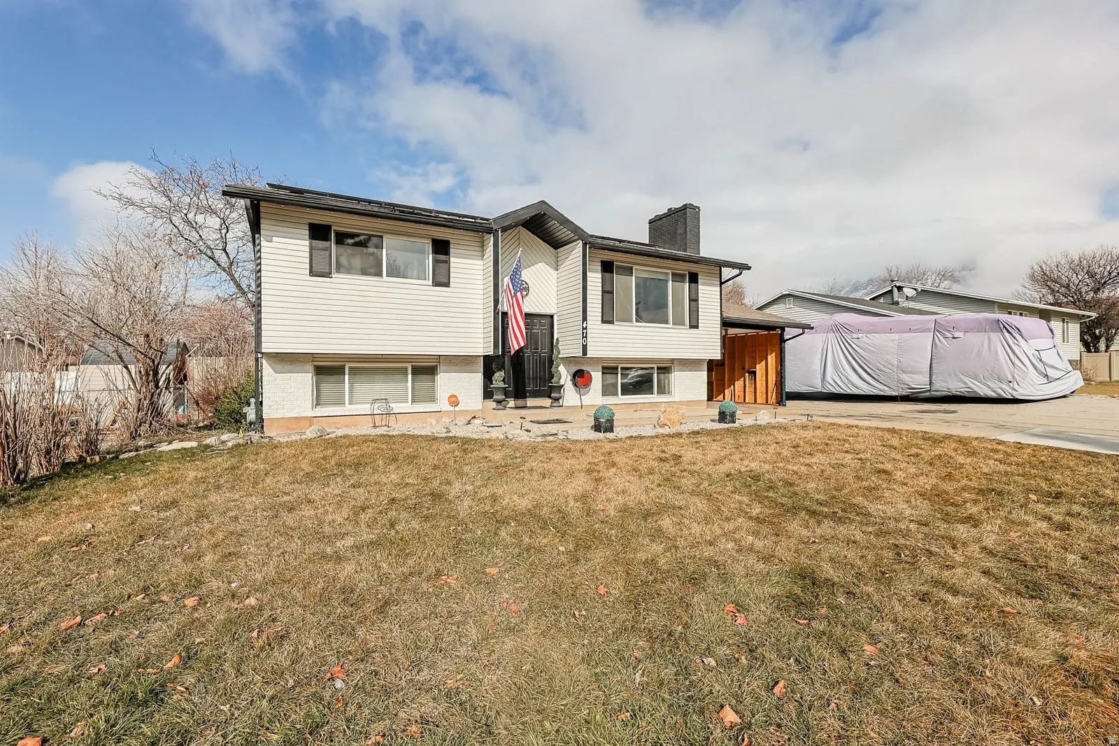 Raised ranch with a front lawn and a chimney