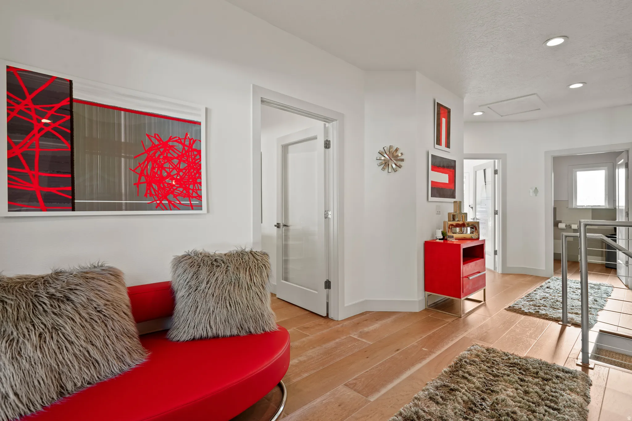Living area with recessed lighting, light wood-style flooring, a textured ceiling, and an upstairs landing