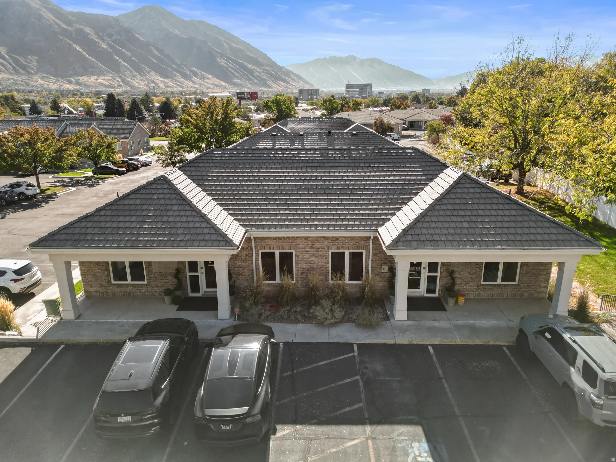 Rear view of house with uncovered parking, brick siding, and a mountain view