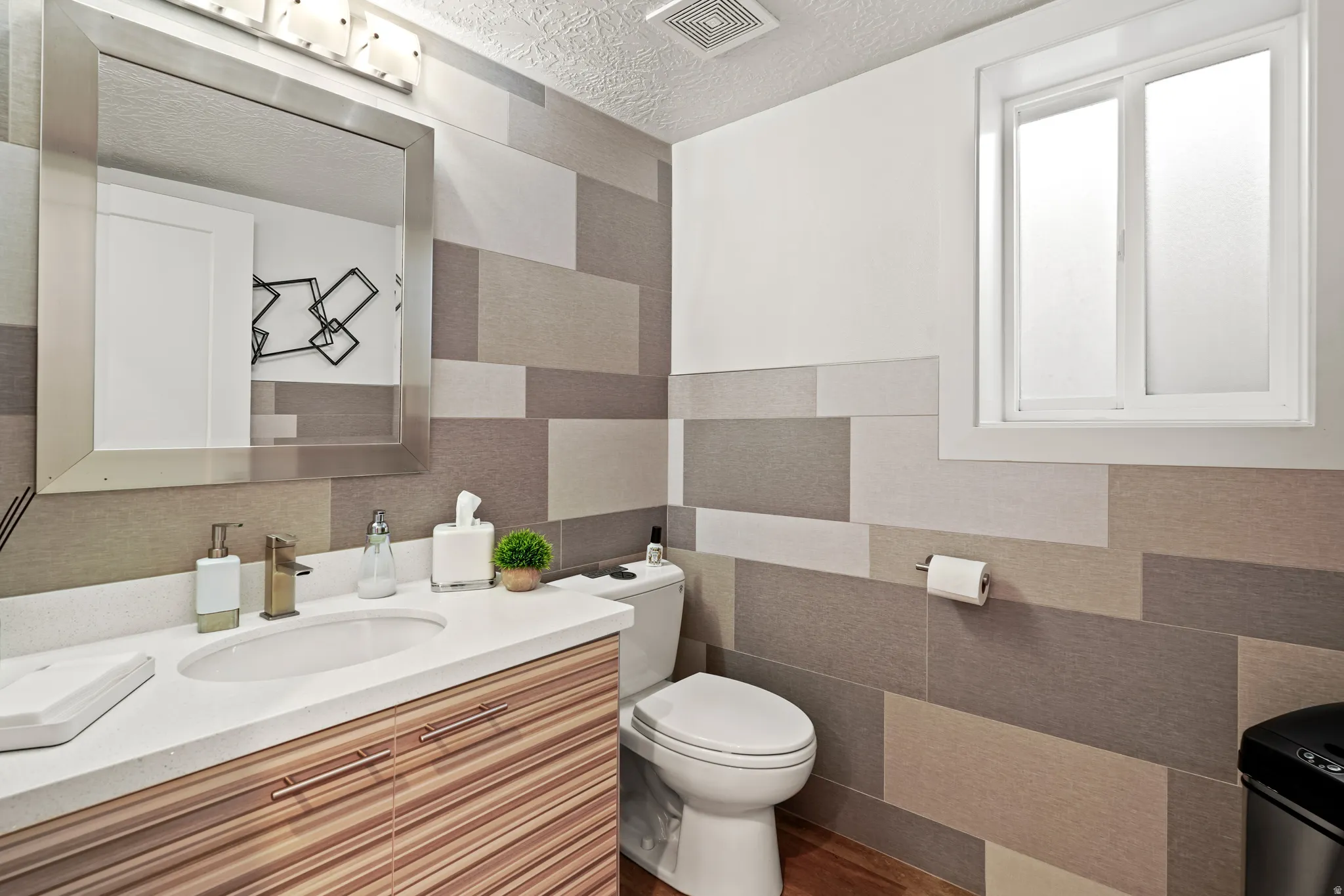 Half bathroom featuring vanity, a textured ceiling, and dark wood finished floors