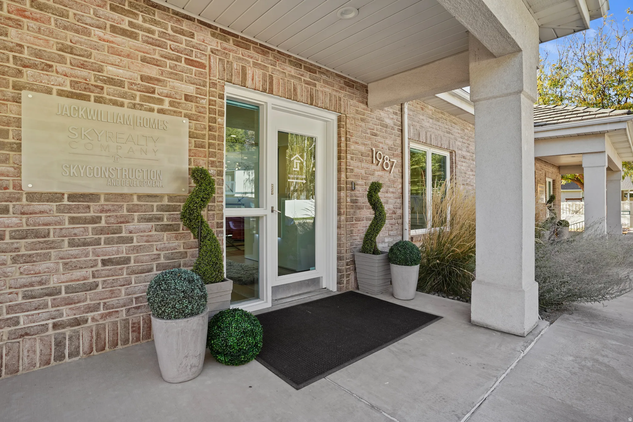 Entrance to property featuring a porch and brick siding