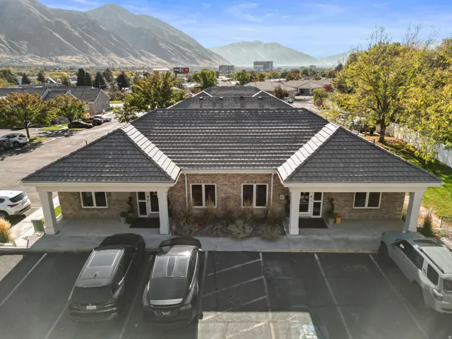 Rear view of house with uncovered parking, brick siding, and a mountain view