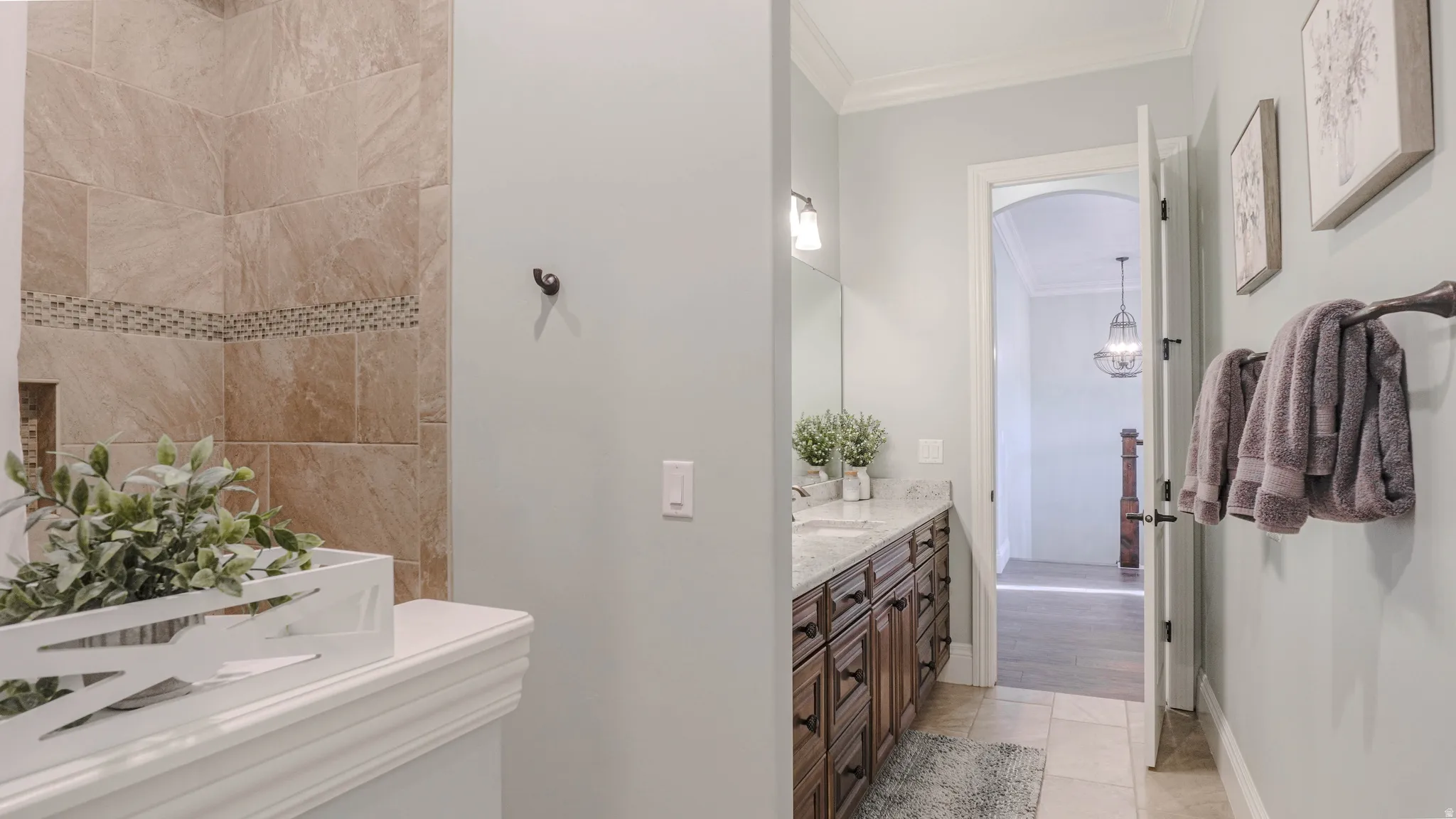 Bathroom with ornamental molding, vanity, and light tile patterned flooring