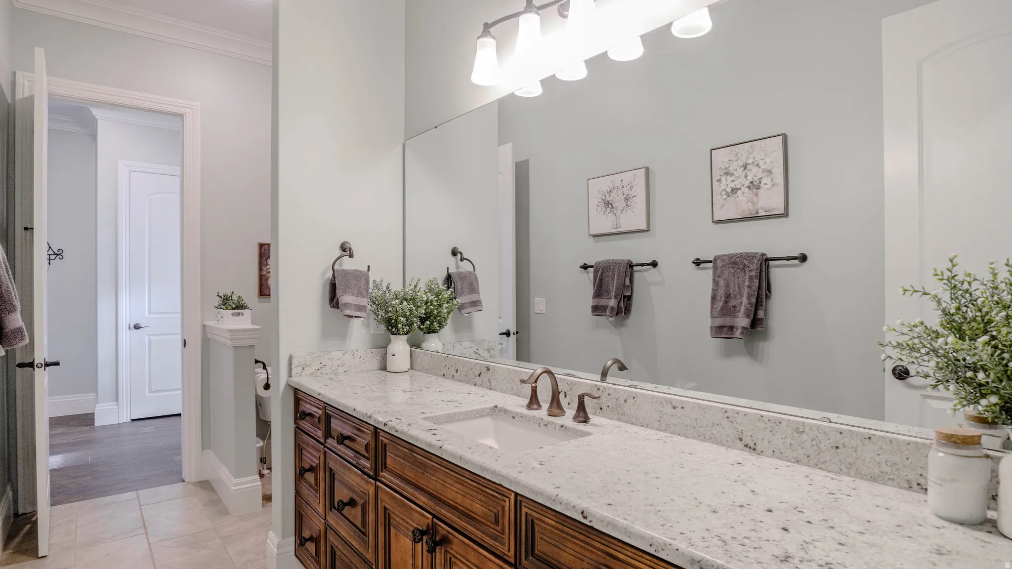 Full bathroom with vanity, crown molding, and light tile patterned flooring