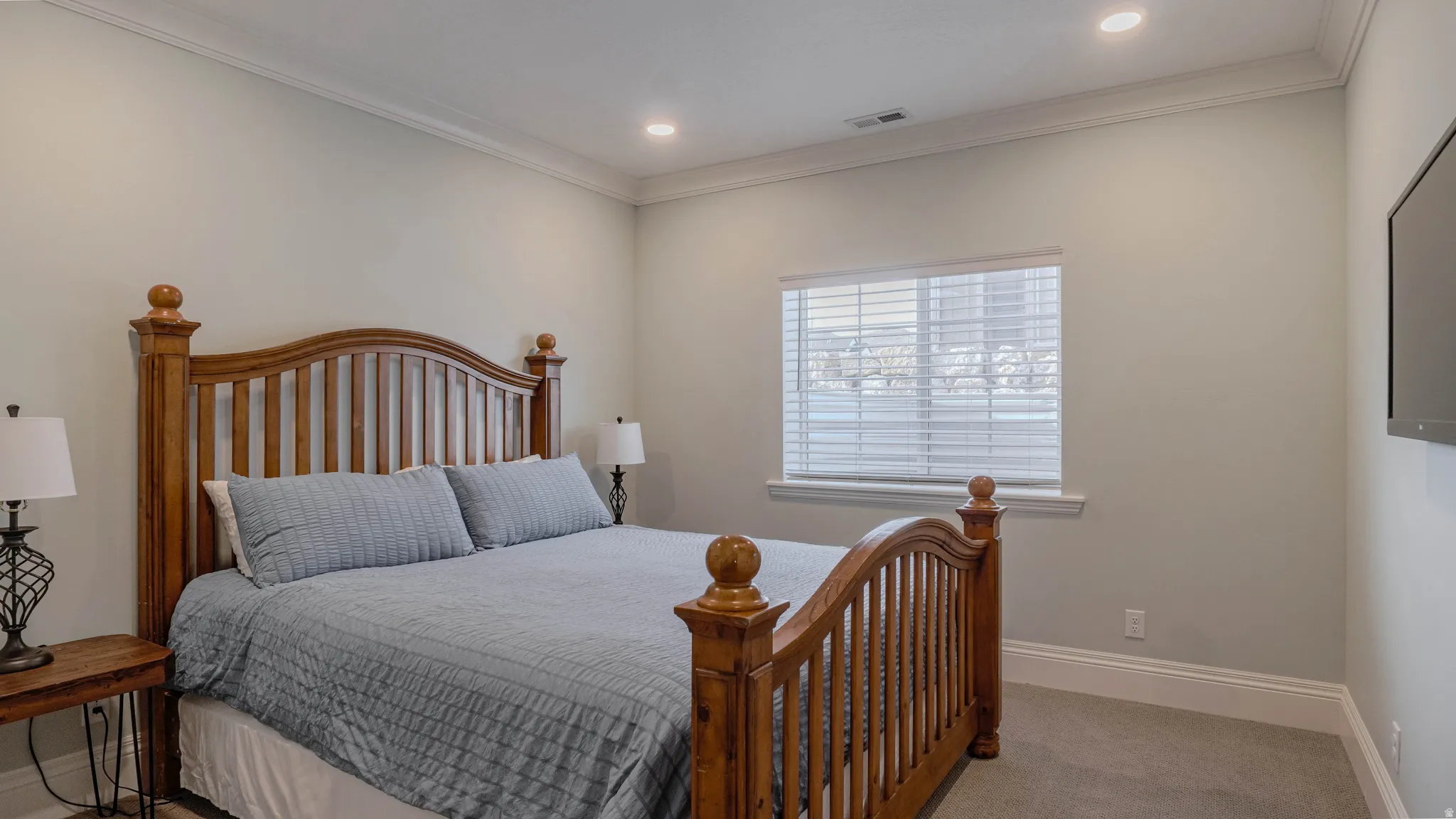 Carpeted bedroom featuring crown molding and recessed lighting