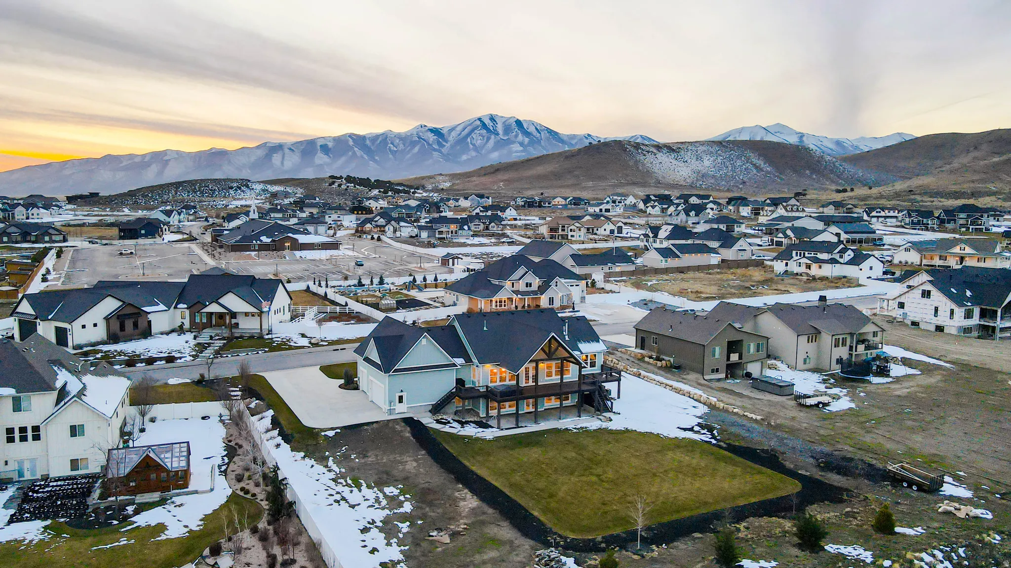 Snowy aerial view featuring a mountain view and a residential view