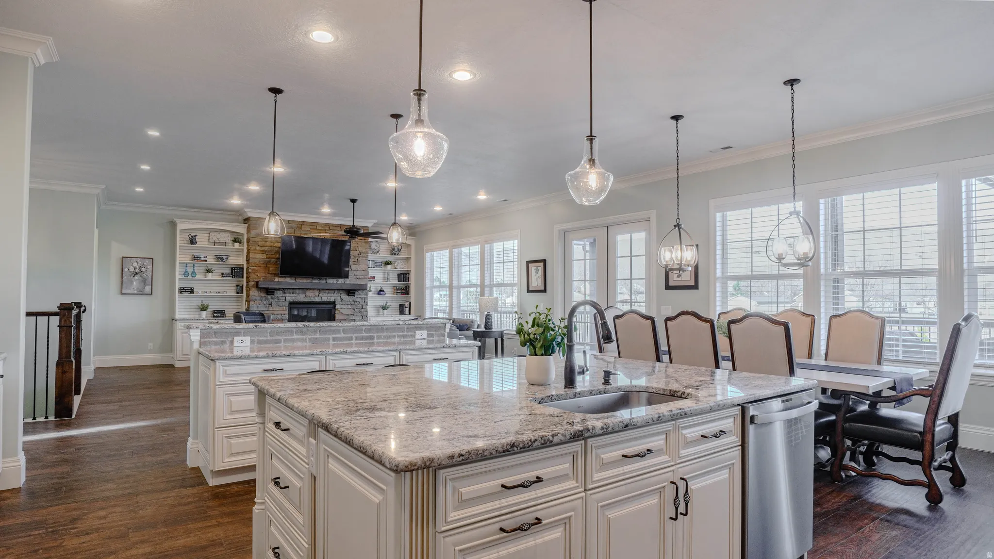 Kitchen featuring light stone countertops, a center island with sink, white cabinetry, dark wood finished floors, and recessed lighting