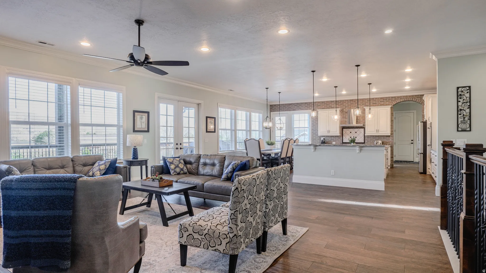 Living area with french doors, ornamental molding, recessed lighting, dark wood-style flooring, and a ceiling fan