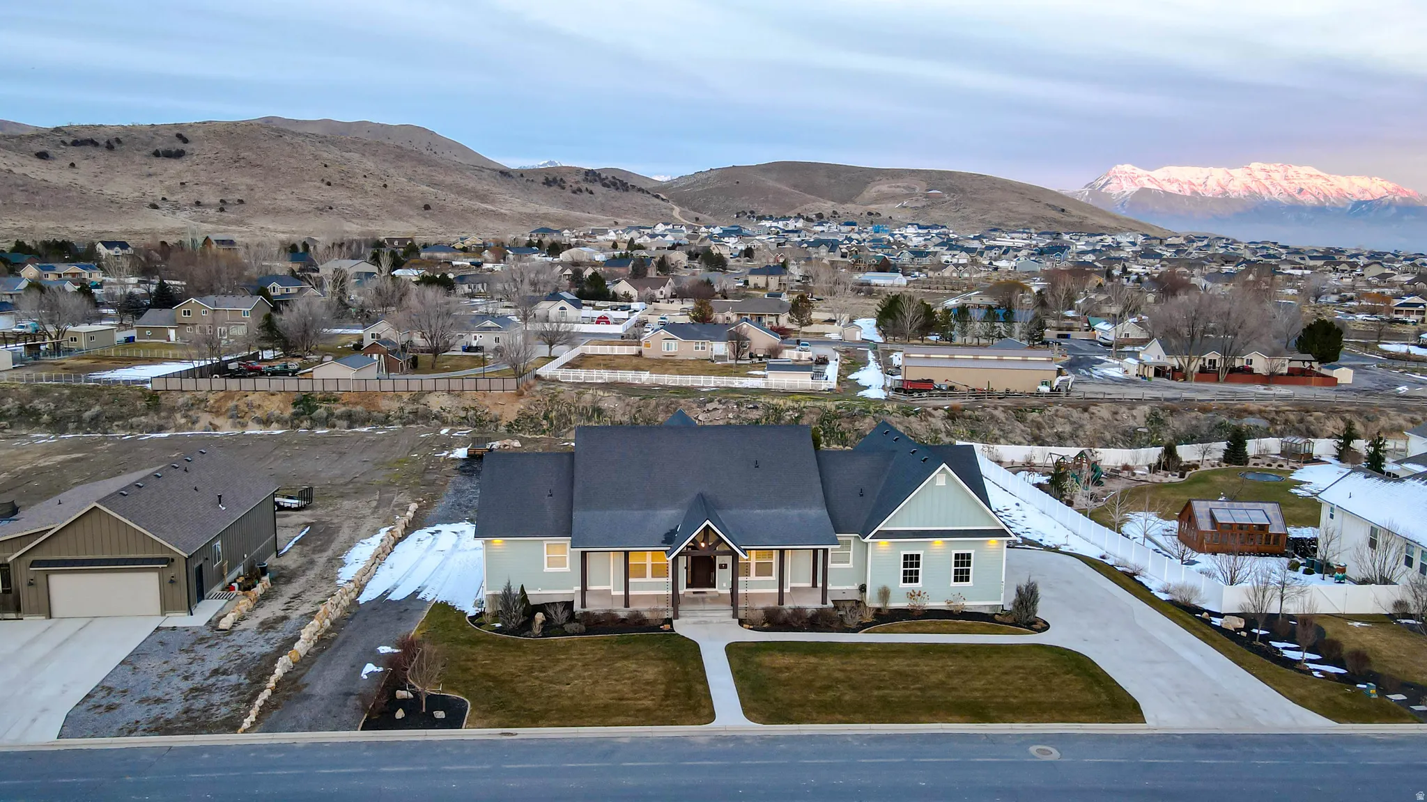 View of front of home featuring a porch, a residential view, a mountain view, driveway, and a front yard