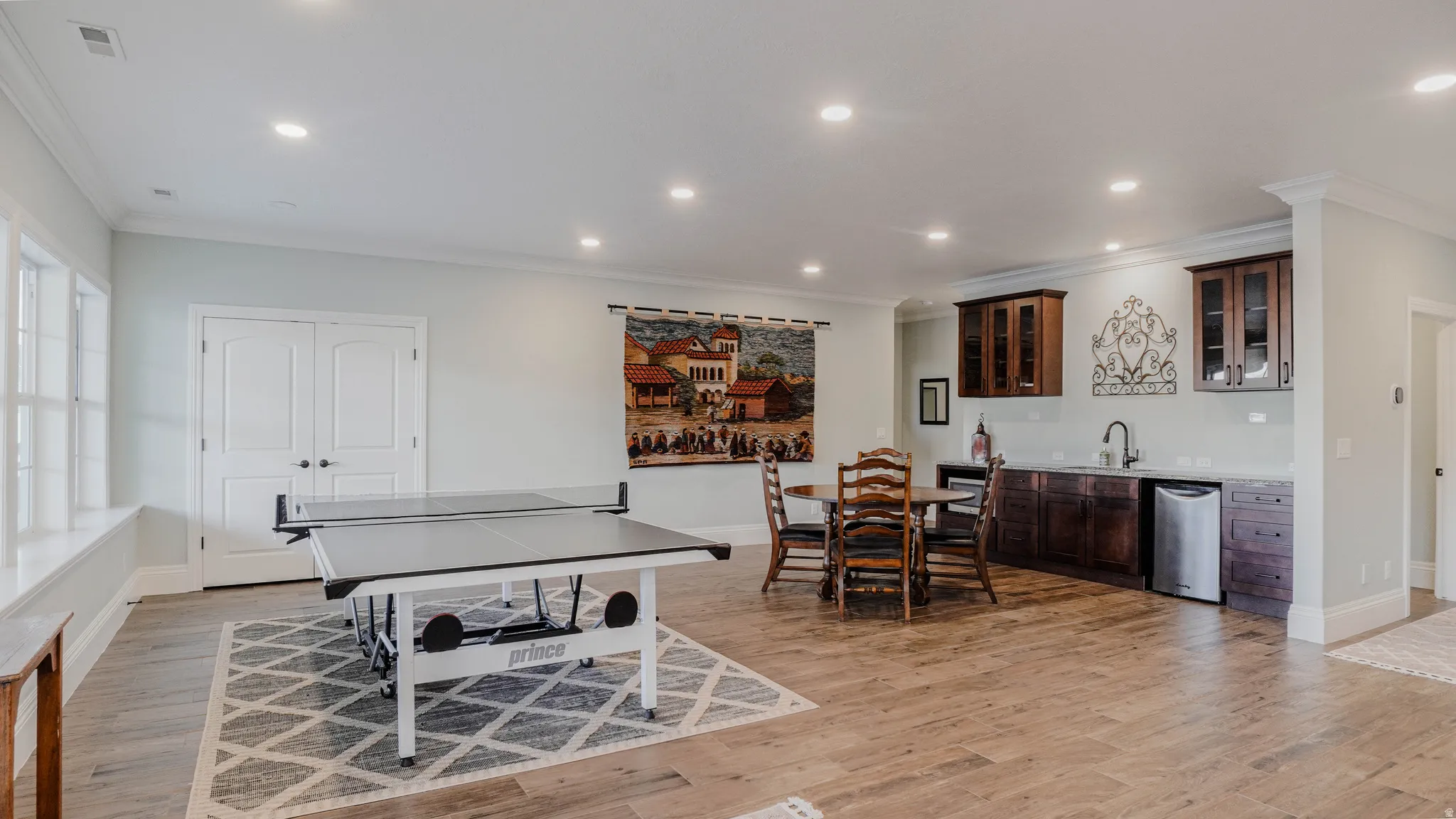 Game room with recessed lighting, ornamental molding, and light wood-style flooring