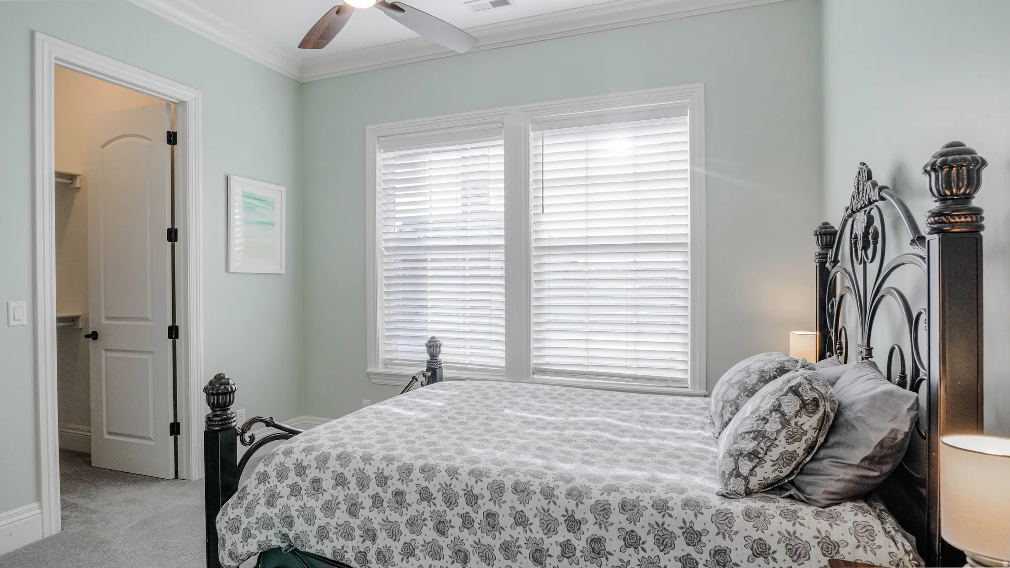 Bedroom featuring ornamental molding, light carpet, and ceiling fan