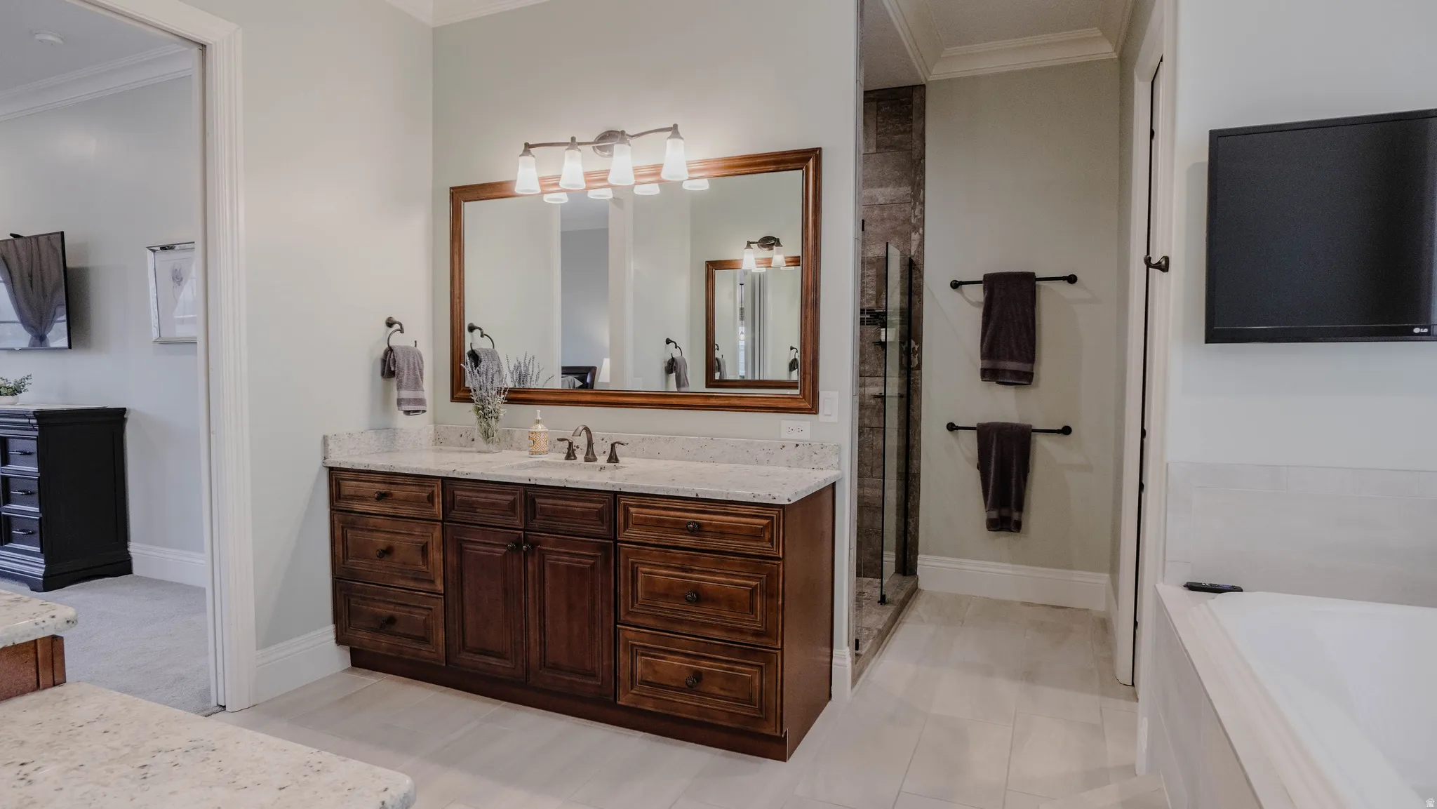 Full bath featuring crown molding, vanity, a garden tub, and a shower stall