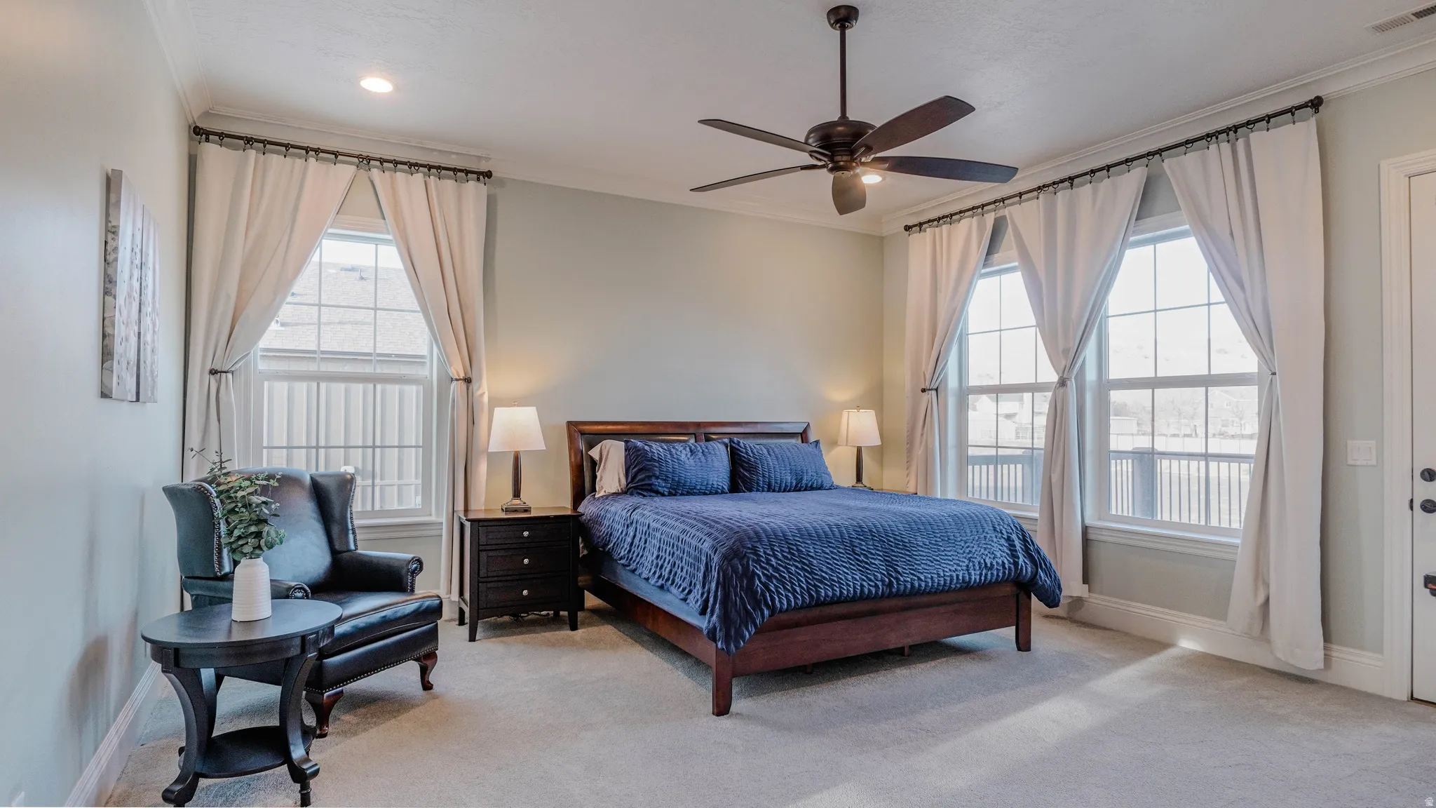 Bedroom featuring ornamental molding, carpet, and a ceiling fan